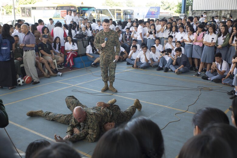 U.S. Marine Corps Gunnery Sgt. Matthew Nightwine, quality assurance chief, and Cpl. Jonathan Castillo, an airframe mechanic with Marine All-Weather Fighter Attack Squadron (VMFA(AW)) 225, demonstrate Marine Corps Martial Arts Program techniques during a visit at Sekolah Menengah Eben Haezar Manado High School in Manado, Indonesia, Nov. 9, 2016. As part of a community relations event, the visit offered service members the opportunity to engage in cultural exchanges and build relationships within the local community. The Marines and Sailors then played basketball against the school basketball teams, losing 50-22 after playing three games. (U.S. Marine Corps photo by Cpl. Aaron Henson)