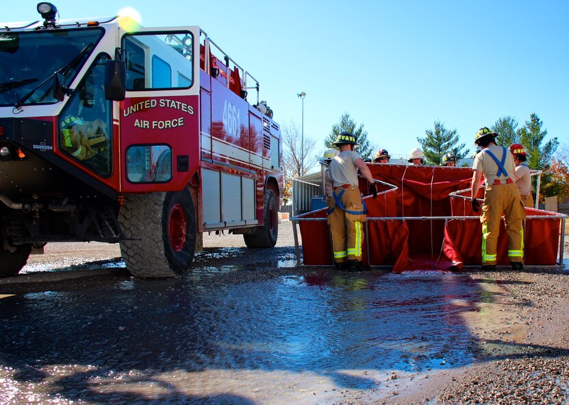 932nd Airlift Wing firefighters train with a Scott Air Force base fire truck and release water from a holding bladder during an early Sunday morning event on November 13, 2016.  Men and women in the Air Force Reserve Command fire crews at Scott are part of the 932nd Civil Engineering Squadron, under the 932nd Mission Support Group.  They improve the unit throughout the year by maintaining fitness, equipment, and skills readiness constantly, and by attending special classes and exercises like Silver Flag, to execute the mission and stay ready.  (U.S. Air Force photo by Lt. Col. Stan Paregien)