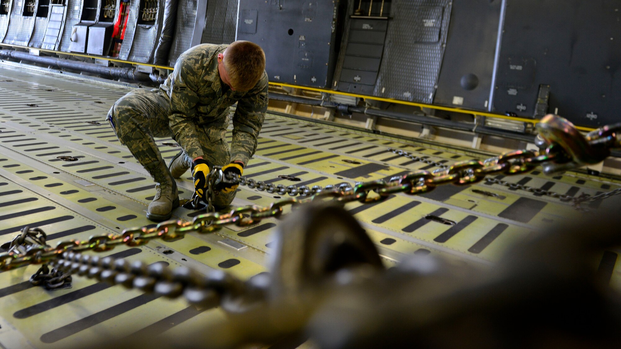 Airman 1st Class Jake Carlson, 724th Air Mobility Squadron aircraft services specialist, secures an all-terrain vehicle to a C-5M Super Galaxy with chains at Aviano Air Base, Italy on Nov. 8, 2016. The vehicles were transported to support operation efforts in Iraq. (U.S. Air Force photo by Senior Airman Cary Smith)