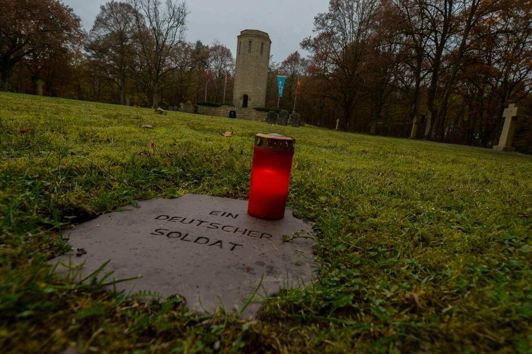 A candle remains lit on top of a grave marker of an unknown German soldier before a German National Day of Mourning observance ceremony at the Kolmeshöhe Military Cemetery in Bitburg, Germany, Nov. 13, 2016. The day, known as Volkstrauertag in German, observes the human cost of warfare and suffering.  (U.S. Air Force photo by Staff Sgt. Joe W. McFadden)