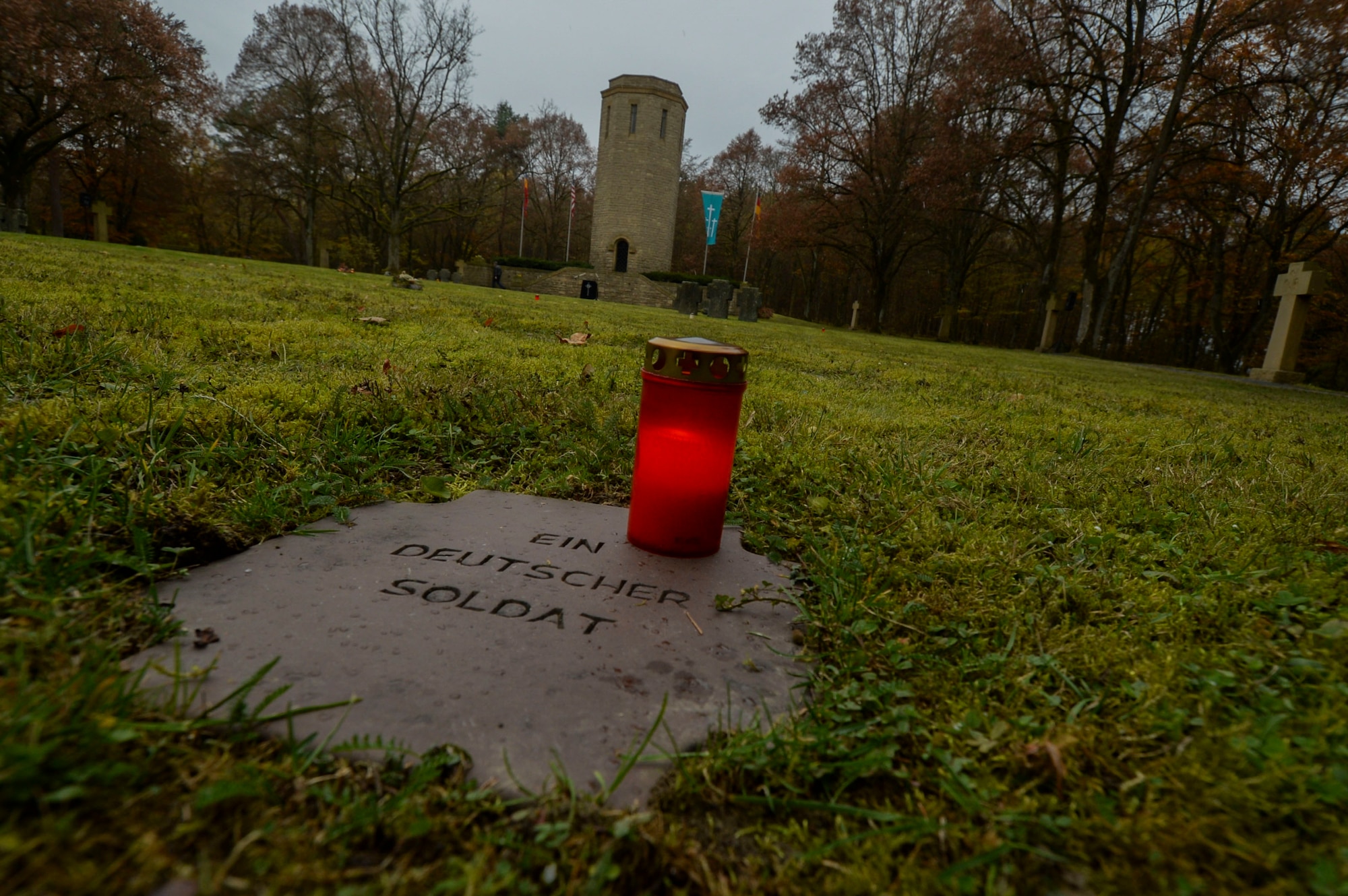 A candle remains lit on top of a grave marker of an unknown German soldier before a German National Day of Mourning observance ceremony at the Kolmeshöhe Military Cemetery in Bitburg, Germany, Nov. 13, 2016. The day, known as Volkstrauertag in German, observes the human cost of warfare and suffering.  (U.S. Air Force photo by Staff Sgt. Joe W. McFadden)