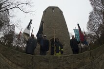 German soldiers and citizens hold up flags during a German National Day of Mourning observance ceremony at the Kolmeshöhe Military Cemetery in Bitburg, Germany, Nov. 13, 2016. The day, known as Volkstrauertag in German, observes the human cost of war and was established following the conclusion of the First World War. (U.S. Air Force photo by Staff Sgt. Joe W. McFadden)