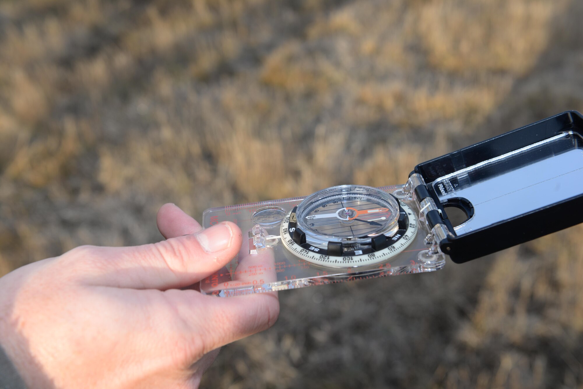 An Airman from the 5th Operations Support Squadron weather flight checks direction on a compass at Minot Air Force Base, N.D., Nov. 8, 2016. Solar panels must face an exact direction to ensure an adequate amount of sunlight reaches tactical weather equipment as a backup power source. (U.S. Air Force photo/Airman 1st Class Jessica Weissman)