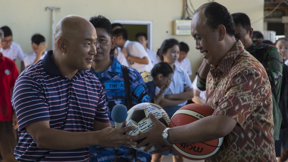 U.S. Navy Lt. Cmdr. Philip Park, left, command chaplain with Marine Aircraft Group 12, gives Jemmy Jermias, the school principal, gifts from the Marines and Sailors with Marine All-Weather Fighter Attack Squadron 225 during a visit at Sekolah Menengah Eben Haezar Manado High School in Manado, Indonesia, Nov. 9, 2016. The exchanging of gifts symbolizes each other’s appreciation for cultural exchanges and community relations events. 