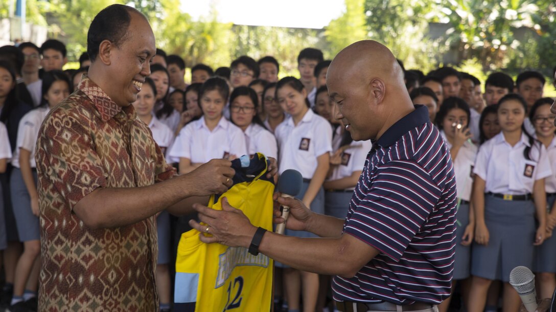 U.S. Navy Lt. Cmdr. Philip Park, right, command chaplain with Marine Aircraft Group 12, recieves a school basketball jersey from Jemmy Jermias, the school principal, during a visit at Sekolah Menengah Eben Haezar Manado High School in Manado, Indonesia, Nov. 9, 2016. The exchanging of gifts symbolizes each other’s appreciation for cultural exchanges and community relations events. As part of a community relations event, the visit offered Marines and Sailors with Marine All-Weather Fighter Attack Squadron 225 the opportunity to engage in cultural exchanges and build relationships within the local community. 