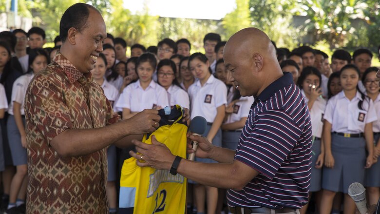 U.S. Navy Lt. Cmdr. Philip Park, right, command chaplain with Marine Aircraft Group 12, recieves a school basketball jersey from Jemmy Jermias, the school principal, during a visit at Sekolah Menengah Eben Haezar Manado High School in Manado, Indonesia, Nov. 9, 2016. The exchanging of gifts symbolizes each other’s appreciation for cultural exchanges and community relations events. As part of a community relations event, the visit offered Marines and Sailors with Marine All-Weather Fighter Attack Squadron 225 the opportunity to engage in cultural exchanges and build relationships within the local community. 