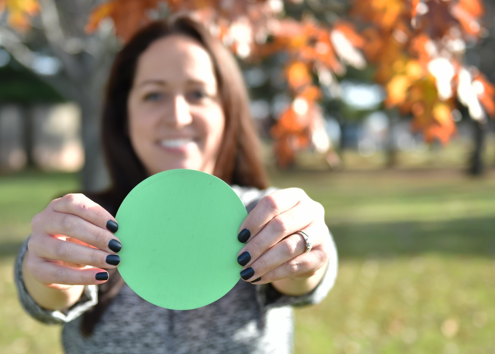 Kelly Turner, Green Dot facilitator and 910th Airlift Wing Drug Demand Reduction Program Manager, displays a Green Dot here, Nov. 6, 2016. The Green Dots will be placed throughout the installation as a way to stir up conversation to encourage positive action when it comes to reacting to instances of interpersonal violence. (U.S. Air Force photo/Staff. Sgt. Rachel Kocin) 
