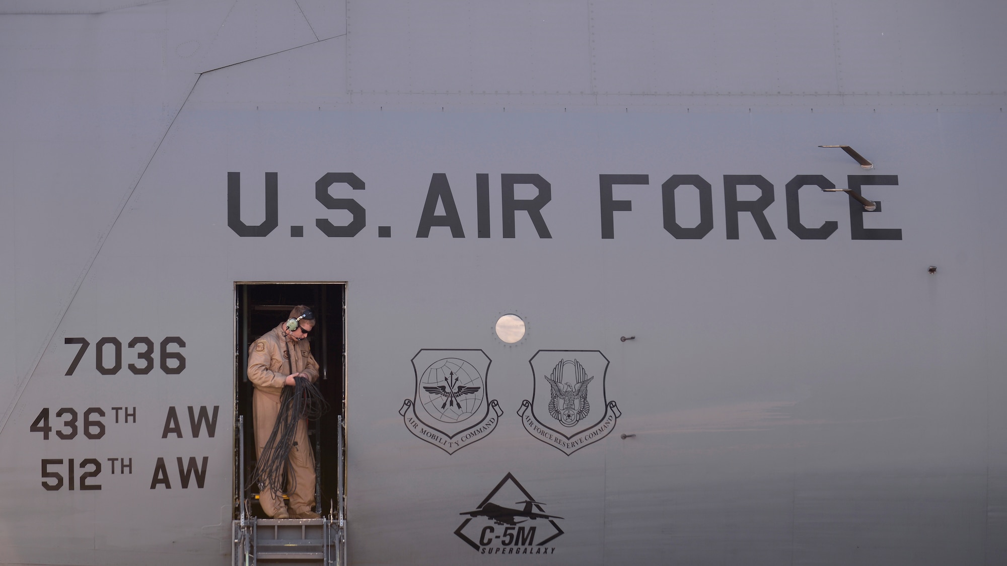 Staff Sergeant Brian Covert, 9th Airlift Squadron flight engineer, gathers communication chords during post-flight duties at Aviano Air Base, Italy on Nov. 8, 2016. The C-5M arrived at Aviano for cargo loading on its way to Iraq. Two teams spent approximately two hours loading and securing the cargo before the C-5 was prepared for takeoff. (U.S. Air Force photo by Senior Airman Cary Smith)
