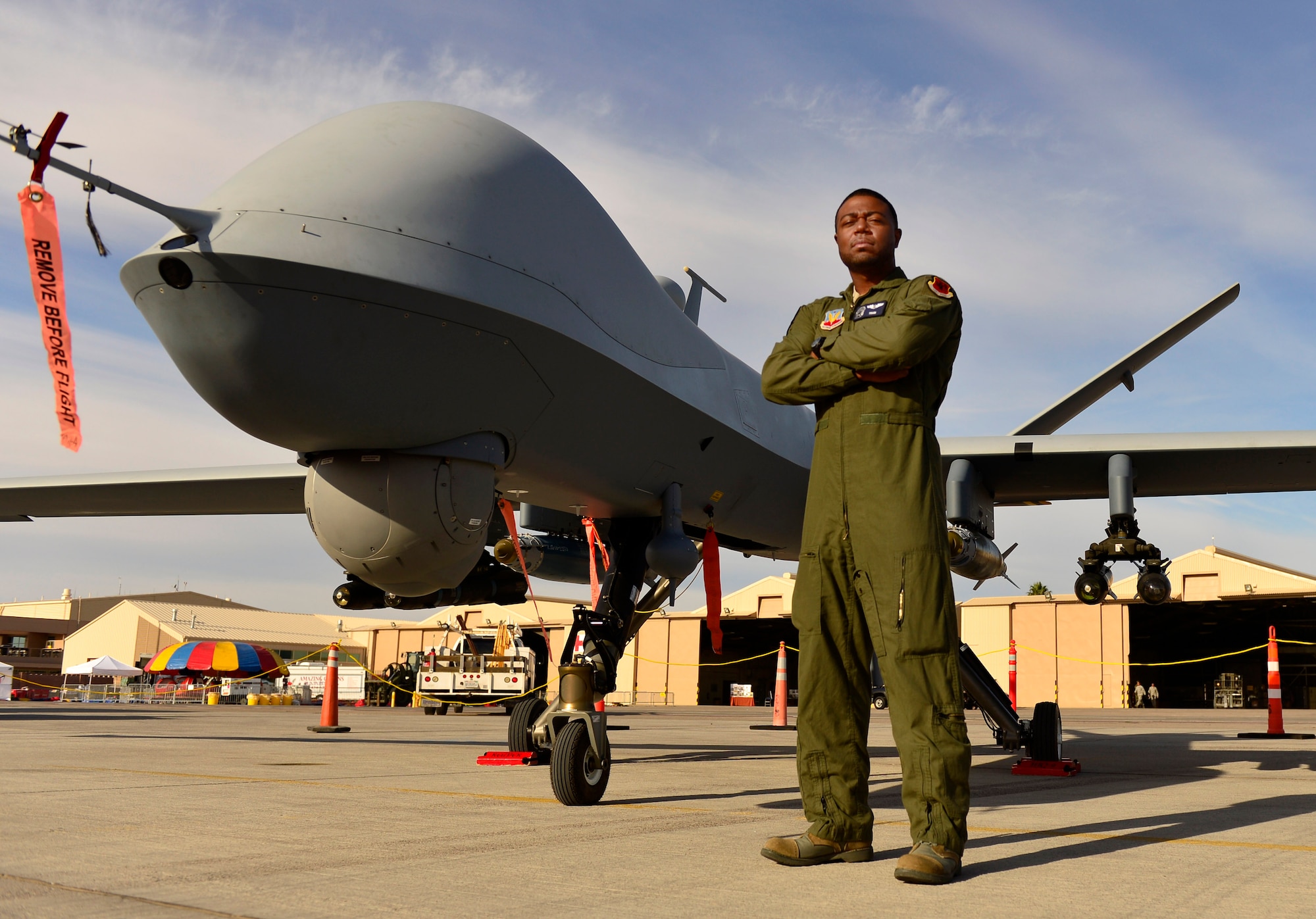 Staff Sgt. Kenneth, 432nd Wing MQ-9 sensor operator, stands in front of an MQ-9 Reaper during Aviation Nation Nov. 11, 2016, at Nellis Air Force Base, Nevada. Kenneth, along with many other maintenance, intelligence and aircrew members of Creech Air Force Base, Nevada, briefed spectators about the capabilities and basic functions of the MQ-9 Reaper and MQ-1 Predator. (U.S. Air Force photo by Senior Airman Christian Clausen/Released)