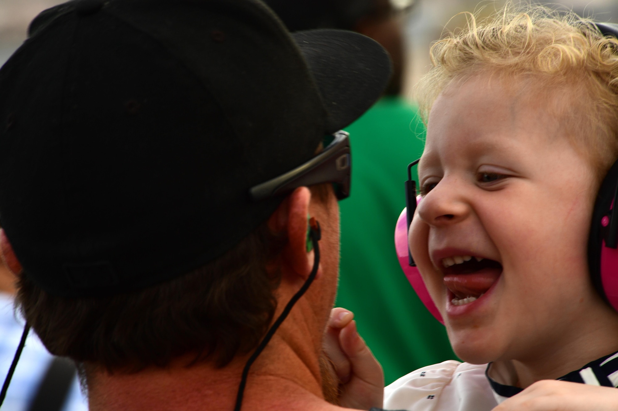 A young girl laughs with her father during Aviation Nation Nov. 12, 2016, at Nellis Air Force Base, Nevada. The air show featured more than 10 aerial demonstrations and more than 50 aircraft displays. (U.S. Air Force photo by Senior Airman Christian Clausen/Released)