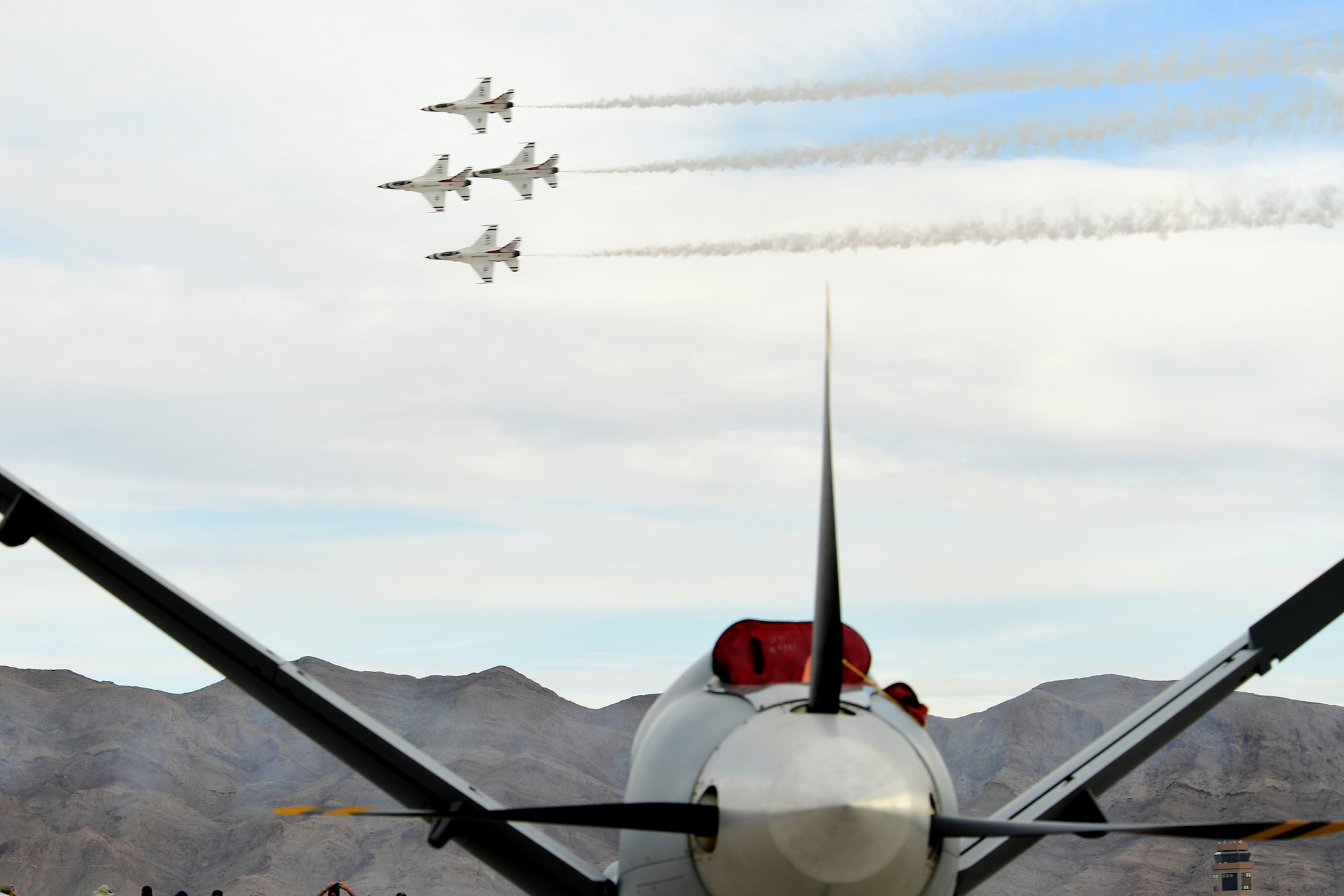 The U.S. Air Force Thunderbird aerial demonstration team pass over an MQ-9 Reaper during Aviation Nation Nov. 12, 2016, at Nellis Air Force Base, Nevada. The MQ-9 Reaper and MQ-1 Predator attracted many curious spectators interested to learn how the aircraft worked and their capabilities. (U.S. Air Force photo by Senior Airman Christian Clausen/Released)