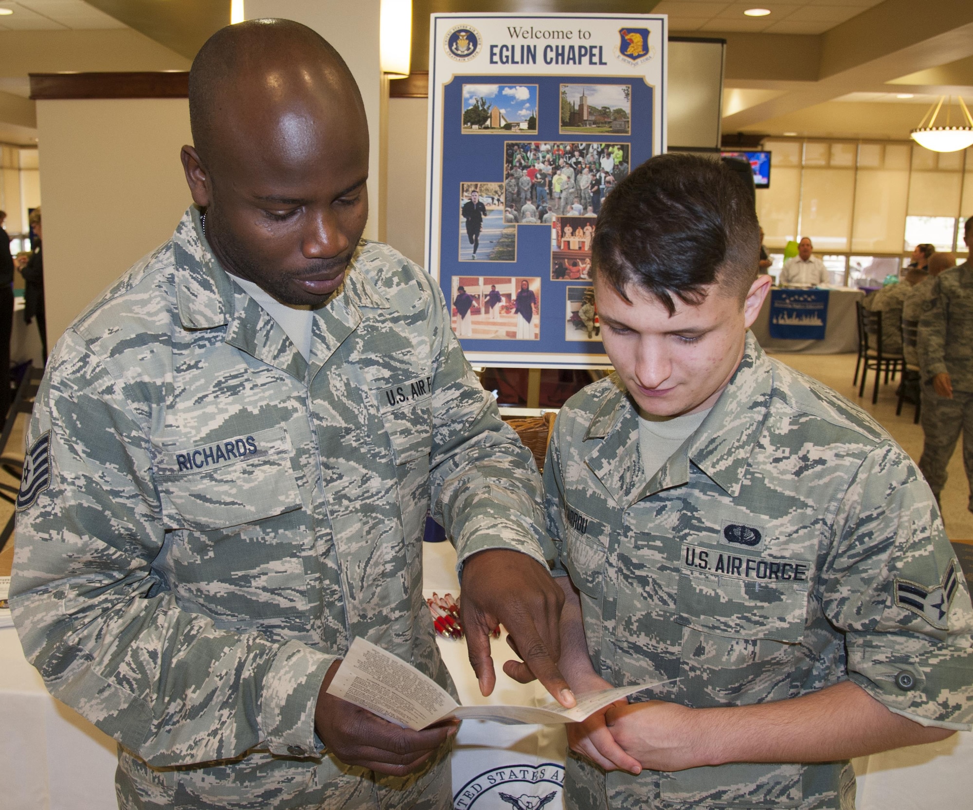 Tech. Sgt. Rudolph Richards, a Chapel assistant, described chapel services to Airman 1st Class Nicholas Gurrou, 96th Force Support Squadron, at the ‘Cornucopia of Care’ event Nov. 9 at the Breeze Dining Facility at Eglin Air Force Base, Fla.  The event brought together 25 base and local agencies who offered attendees reference materials, promotional items and guidance.  (U.S. Air Force photo/Kevin Gaddie)    
