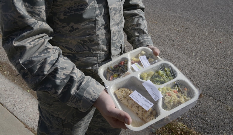 Senior Airman Joseph Todd, Defense Red Switch technician with the 21st Communications Squadron, delivers two dinners while volunteering Nov. 4, in Colorado Springs, Colorado. He brought food to the elderly as part of the Meals on Wheels program. (U.S. Air Force photo by Shellie-Anne Espinosa)
