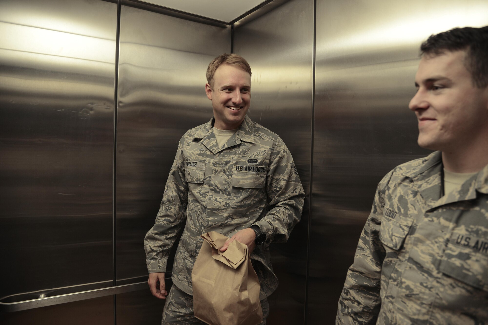 Senior Airmen Eric Paradis and Joseph Todd, both Defense Red Switch technicians with the 21st Communications Squadron, bring food up to a Meals on Wheels recipient’s apartment Nov. 4, in Colorado Springs, Colorado. Both Airmen participated in the program to deliver meals to the elderly. (U.S. Air Force photo by Shellie-Anne Espinosa)