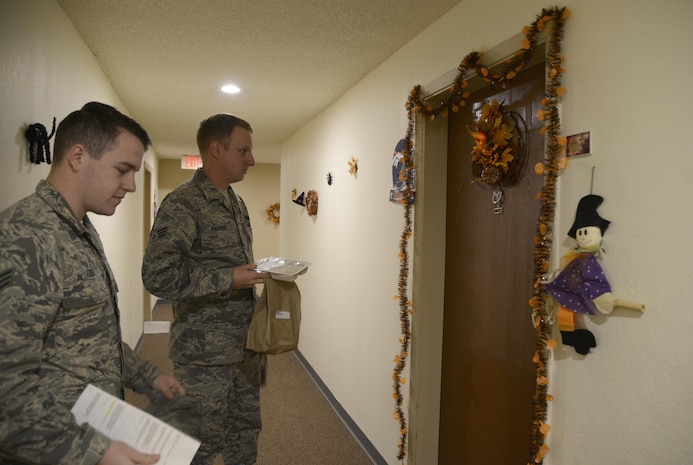 Senior Airmen Joseph Todd and Eric Paradis, both Defense Red Switch technicians with the 21st Communications Squadron, wait outside a senior’s door to deliver her meal Nov. 4, in Colorado Springs, Colorado. Both Airmen participated in Meals on Wheels to deliver food to the elderly. (U.S. Air Force photo by Shellie-Anne Espinosa)

