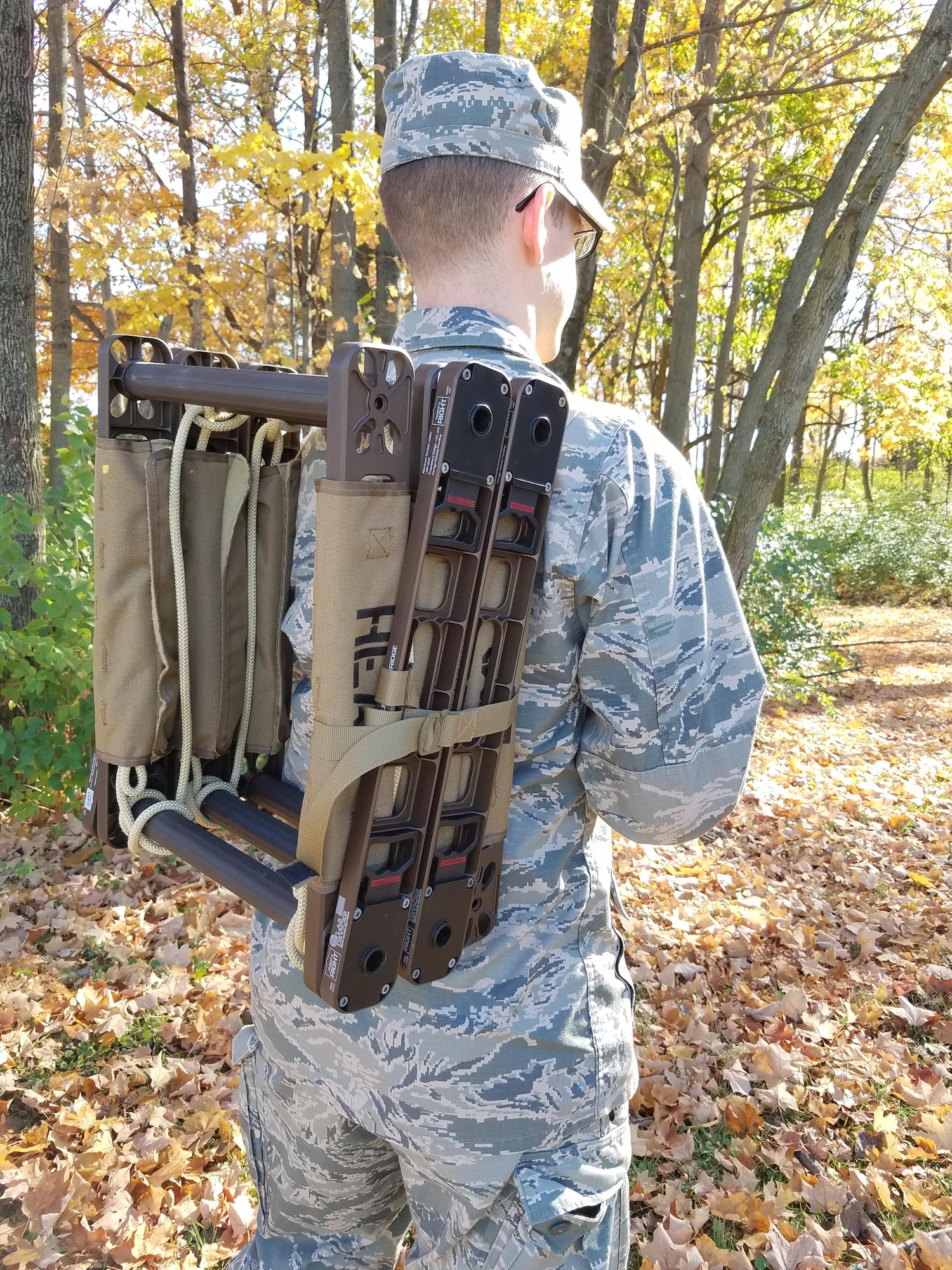 1st Lt. Stuart Baker demonstrates the portability of the JFWORX-developed Roco Atlas Casualty Carrier. This strong and lightweight tactical ladder can also function as bridge between structures and as a stretcher to transport injured personnel. (U.S. Air Force photo/Holly Jordan)