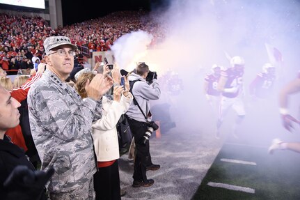 Gen. John E. Hyten, commander of U.S. Strategic Command (USSTRATCOM), applauds as the Nebraska Cornhuskers football team takes the field Nov. 12, 2016 during Nebraska’s game against the Minnesota Golden Gophers, where he was the guest of university president Hank Bounds. The university also provided game tickets to veterans and active duty personnel assigned to USSTRATCOM and area commands as part of the Veterans Day weekend. One of nine DoD unified combatant commands, USSTRATCOM has global strategic missions assigned through the Unified Command Plan that include strategic deterrence; space operations; cyberspace operations; joint electronic warfare; global strike; missile defense; intelligence, surveillance and reconnaissance; combating weapons of mass destruction; and analysis and targeting. (U.S. Navy photo by Petty Officer 1st Class Byron C. Linder)
