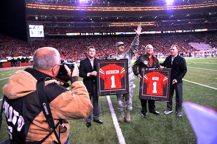 Gen. John E. Hyten, commander of U.S. Strategic Command (USSTRATCOM), center, accepts a “USSTRATCOM” Nebraska Cornhuskers football jersey from University of Nebraska president Hank Bounds Nov. 12, 2016, during Nebraska’s game against the Minnesota Golden Gophers. The university provided game tickets to veterans and active duty personnel assigned to USSTRATCOM and area commands as part of the Veterans Day weekend. One of nine DoD unified combatant commands, USSTRATCOM has global strategic missions assigned through the Unified Command Plan that include strategic deterrence; space operations; cyberspace operations; joint electronic warfare; global strike; missile defense; intelligence, surveillance and reconnaissance; combating weapons of mass destruction; and analysis and targeting. (U.S. Navy photo by Petty Officer 1st Class Byron C. Linder)