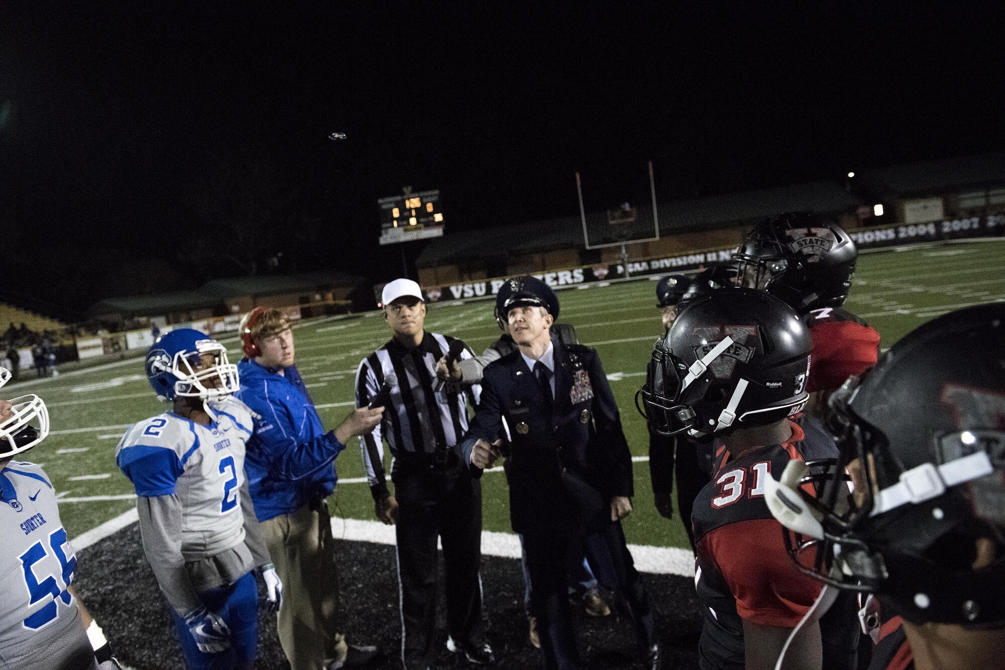 Col. Thomas Kunkel, 23d Wing commander, flips a coin before the beginning of a Valdosta State University military appreciation game, Nov. 12, in Valdosta, Ga. During the coin toss, veterans from every branch of service stood on the field to be applauded. (U.S. Air Force photo by Airman 1st Class Daniel Snider)