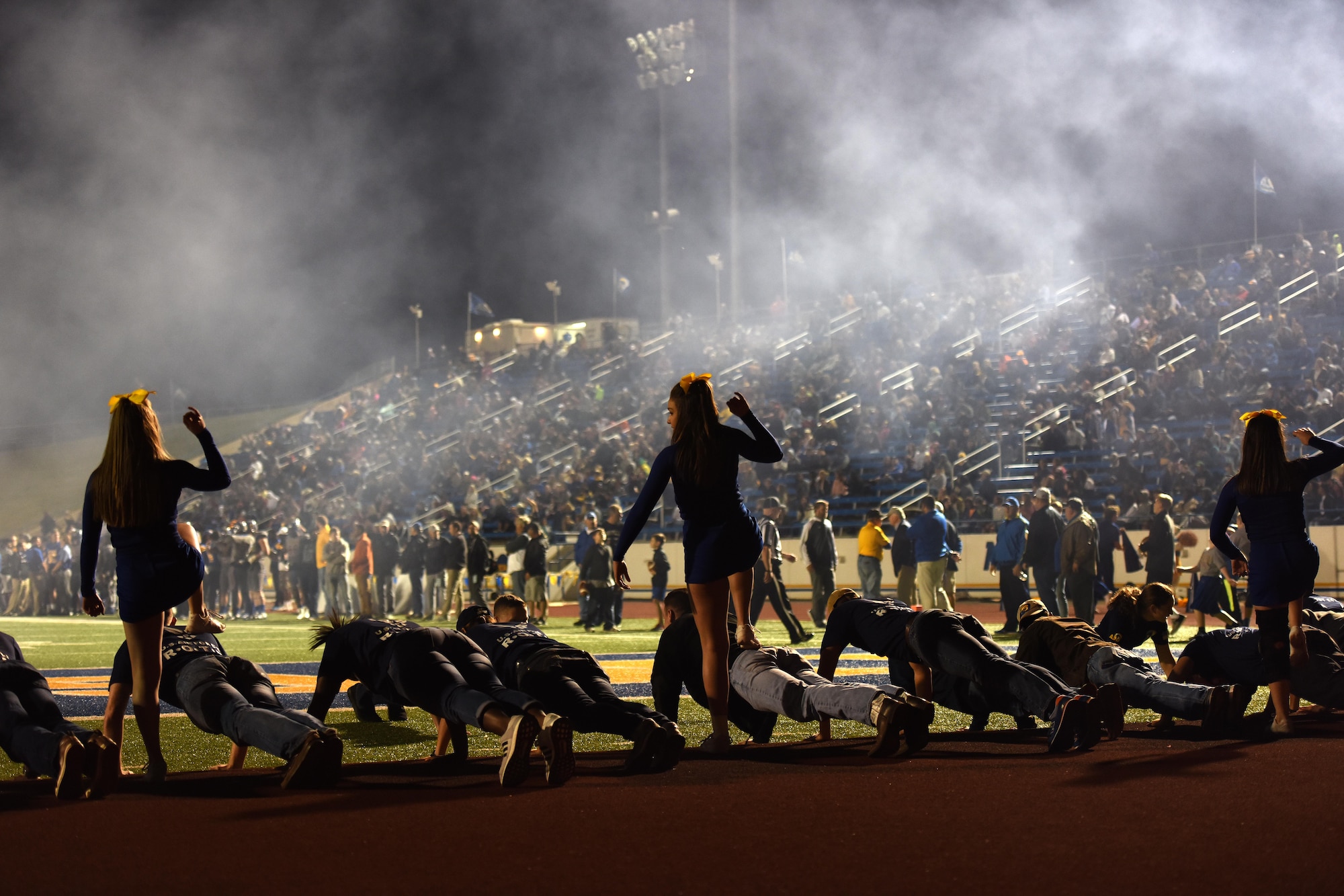 Angelo State University cheerleaders mock step on Junior ROTC units at the ASU Military Appreciation football game at San Angelo Stadium, Texas, Nov. 12, 2016. The Junior ROTC cadets performed pushups every time ASU scored a touchdown. (U.S. Air Force photo by Airman 1st Class Caelynn Ferguson/Released)