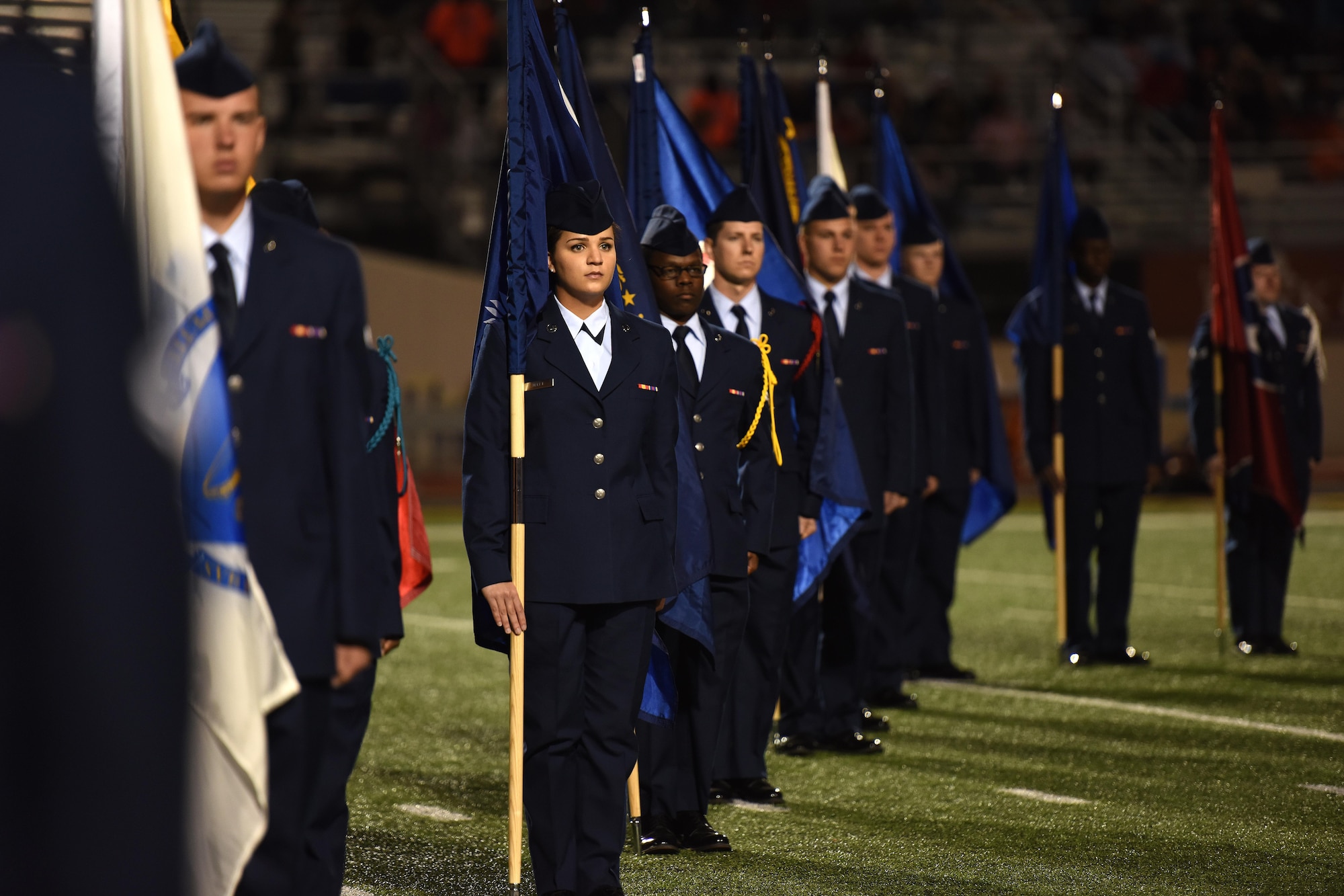 Goodfellow volunteers hold state flags during half-time of the Angelo State University Military Appreciation football game at the San Angelo Stadium, Texas, Nov. 12, 2016. The volunteers came from multiple training squadrons on Goodfellow Air Force Base. (U.S. Air Force photo by Airman 1st Class Caelynn Ferguson/Released)