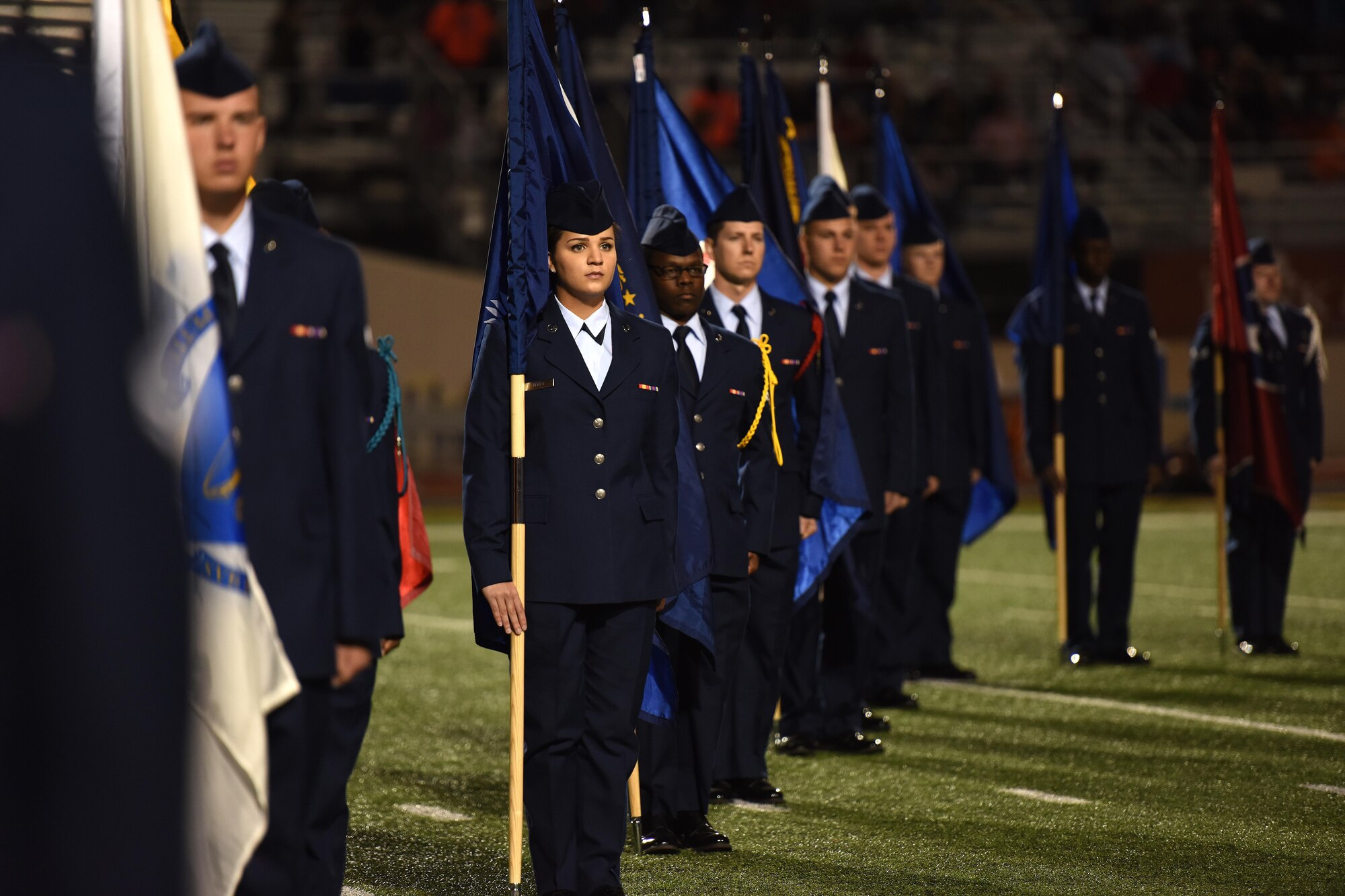 Goodfellow volunteers hold state flags during half-time of the Angelo State University Military Appreciation football game at the San Angelo Stadium, Texas, Nov. 12, 2016. The volunteers came from multiple training squadrons on Goodfellow Air Force Base. (U.S. Air Force photo by Airman 1st Class Caelynn Ferguson/Released)