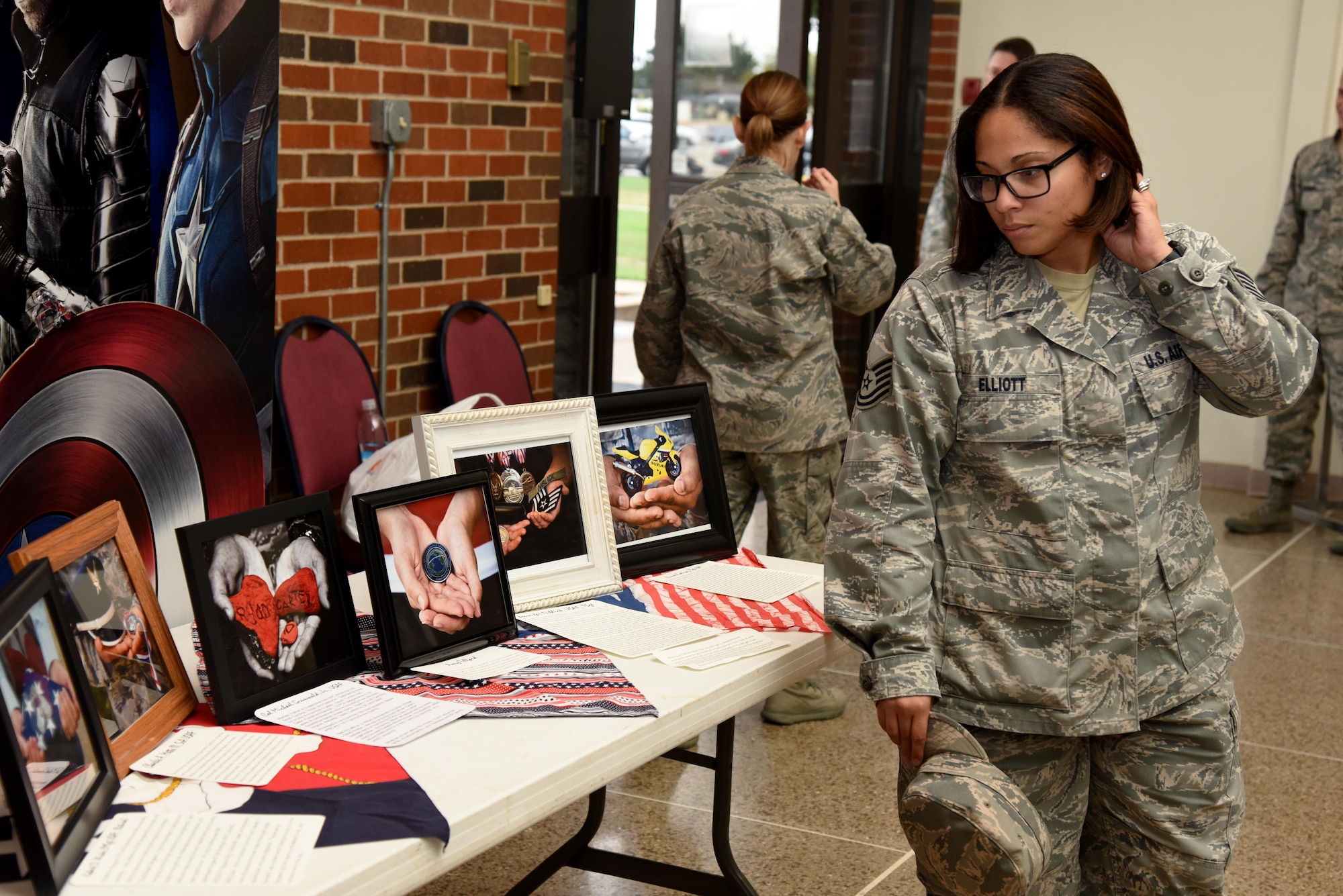 U.S. Air Force Tech. Sgt. Stephanie Elliot, 17th Training Wing executive support NCO in charge, views the Hands Display at the base theater on Goodfellow Air Force Base, Texas, Nov. 10, 2016. All the people in the display used their hands to show a part of their life. All the photos came along with an accompanying story. (U.S. Air Force photo by Senior Airman Joshua Edwards/Released)