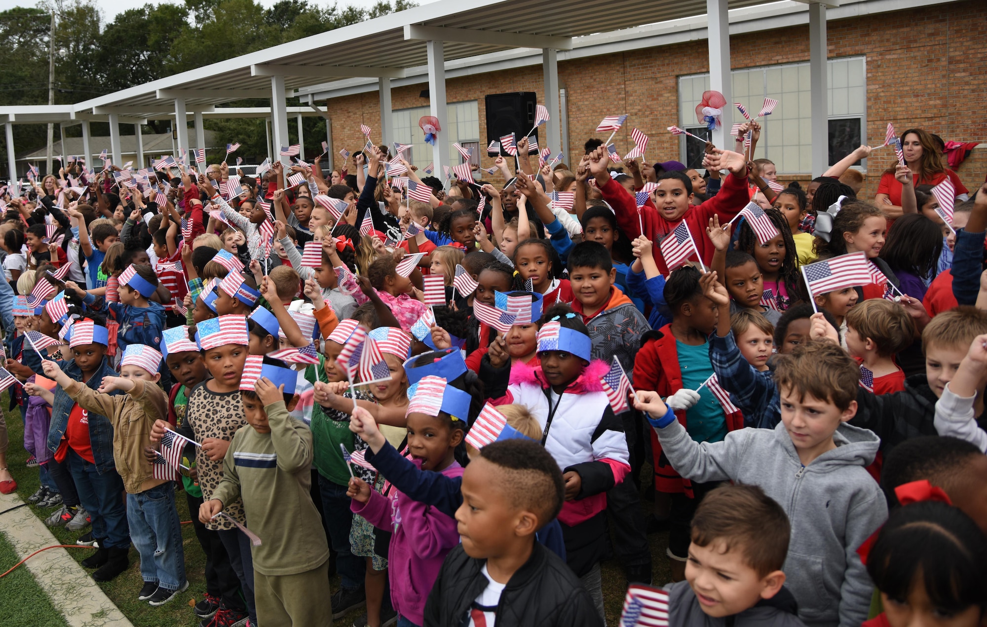 Students at Jeff Davis Elementary School wave their flags during a Veterans Day celebration Nov. 11, 2016, in Biloxi, Miss. During the event, students delivered the Pledge of Allegiance and sang several patriotic songs. Keesler Air Force Base leadership, Honor Guard Airmen and personnel attended the event. (U.S. Air Force photo by Kemberly Groue/Released)
