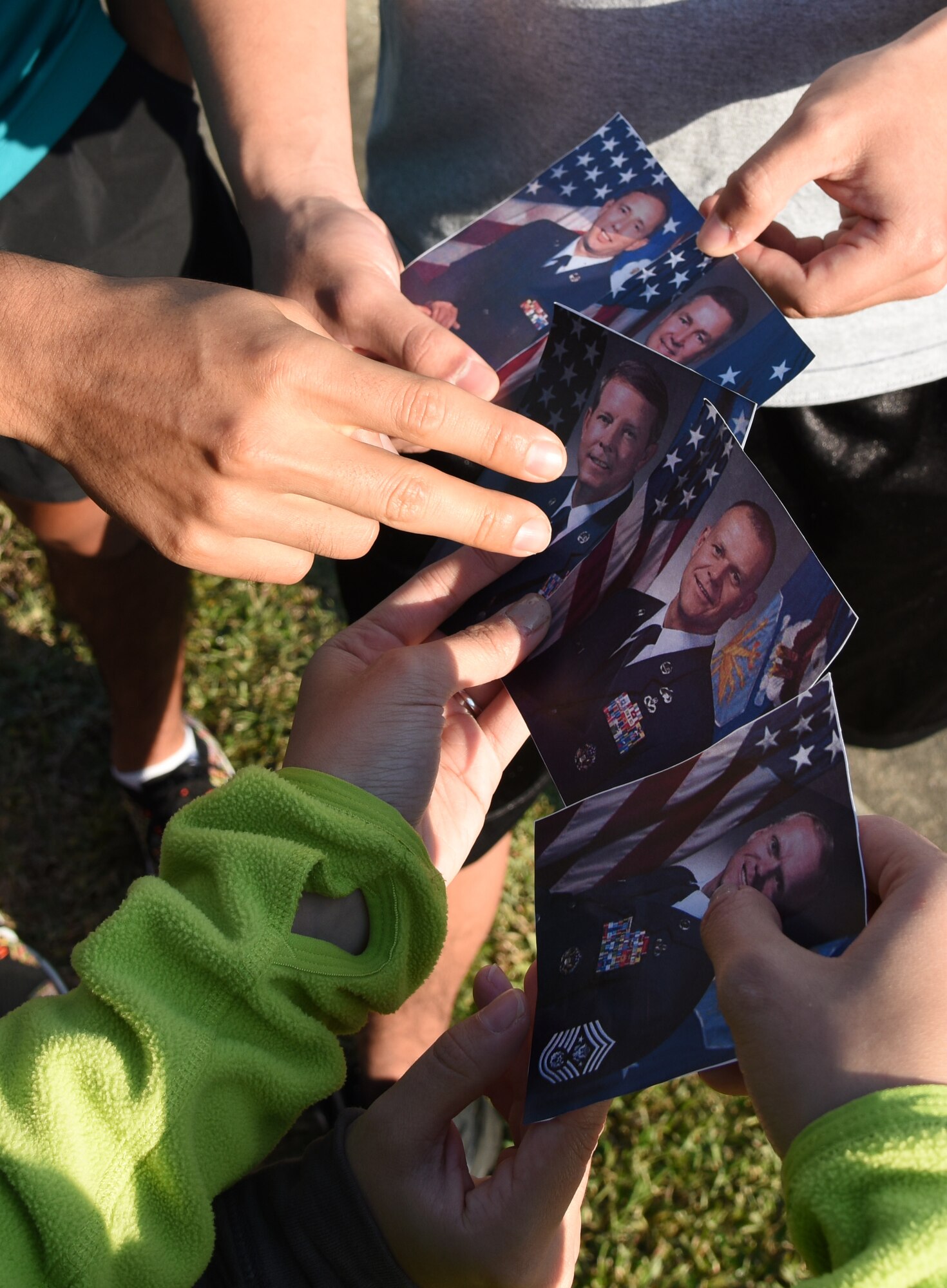 Members of the 81st Medical Group place photos of the last five Chief Master Sergeants  of the Air Force in chronological order in front of the headquarters building during the Dragon Week Dragon Hunt Nov. 14, 2016, on Keesler Air Force Base, Miss. The scavenger hunt, consisting of six teams, kicked-off a week filled with resiliency and teambuilding events. (U.S. Air Force photo by Kemberly Groue/Released)