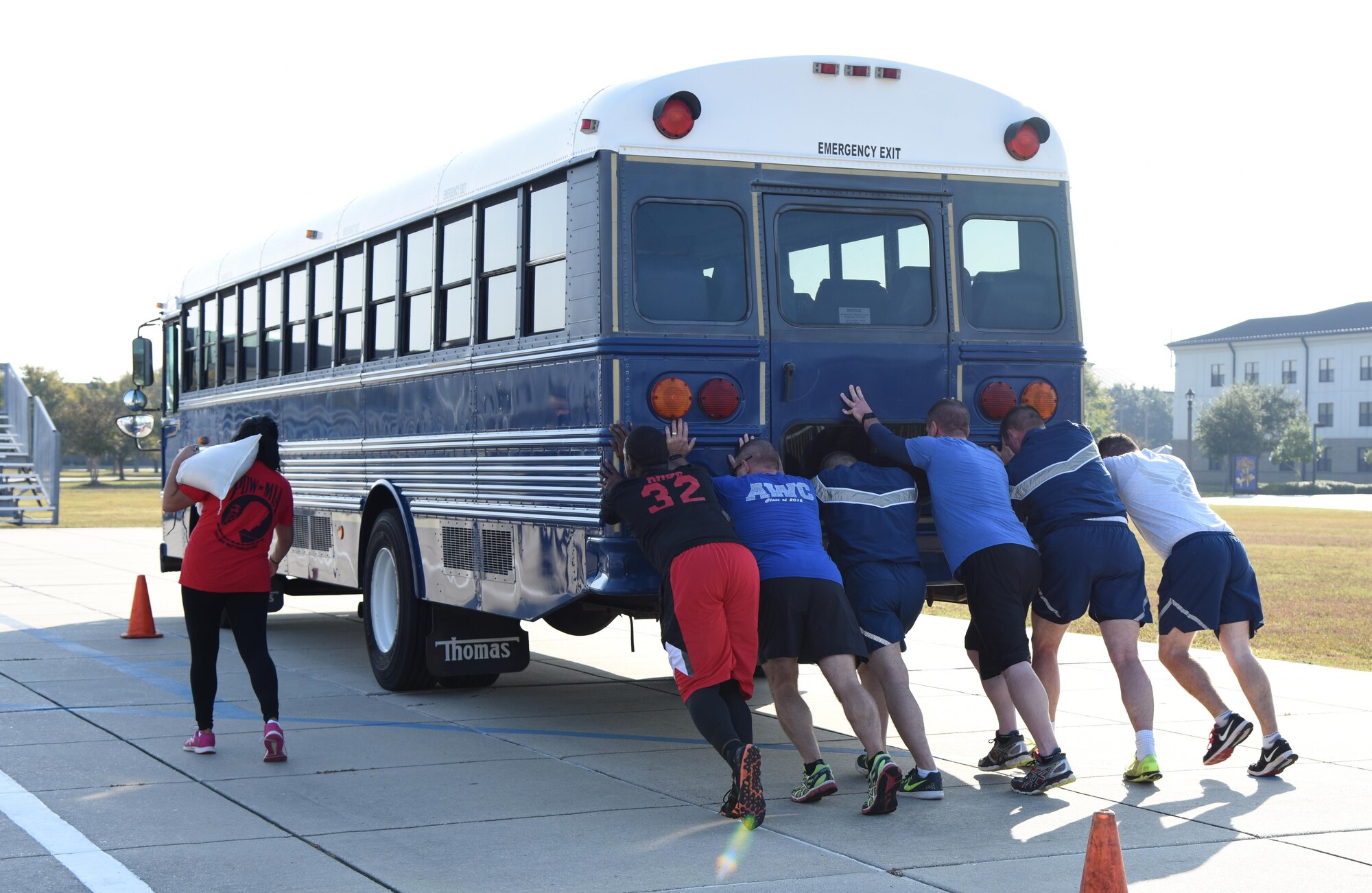 Members of the 81st Training Group team push a bus past a designated cone on the Levitow Training Support Facility drill pad during the Dragon Week Dragon Hunt Nov. 14, 2016, on Keesler Air Force Base, Miss. The scavenger hunt, consisting of six teams, kicked-off a week filled with resiliency and teambuilding events. (U.S. Air Force photo by Kemberly Groue/Released)