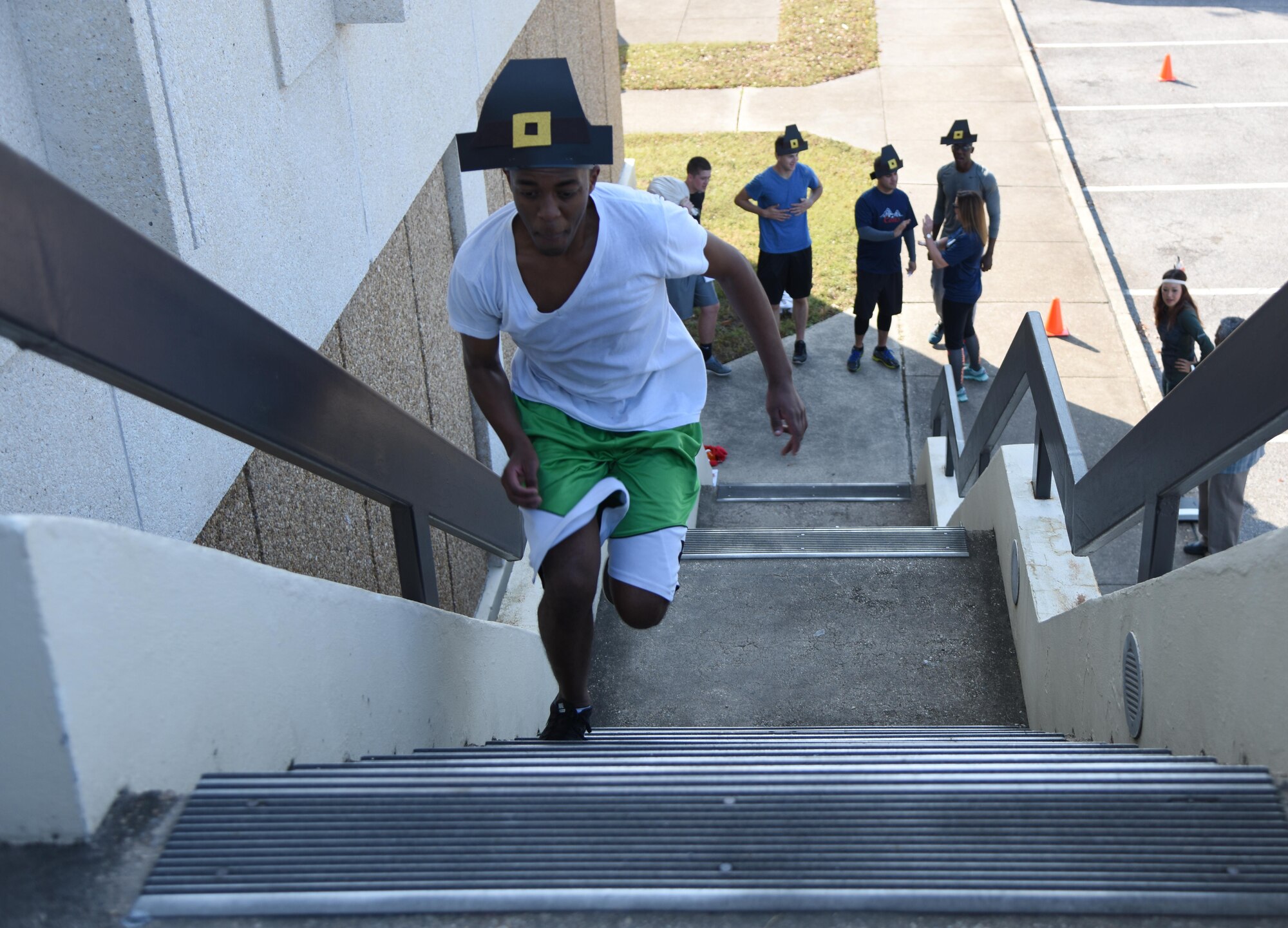 Senior Airman Martin Githui, 81st Contracting Squadron contracting specialist, leads his team in a staircase relay race at the Sablich Center during the Dragon Week Dragon Hunt Nov. 14, 2016, on Keesler Air Force Base, Miss. The scavenger hunt, consisting of six teams, kicked-off a week filled with resiliency and teambuilding events. (U.S. Air Force photo by Kemberly Groue/Released)