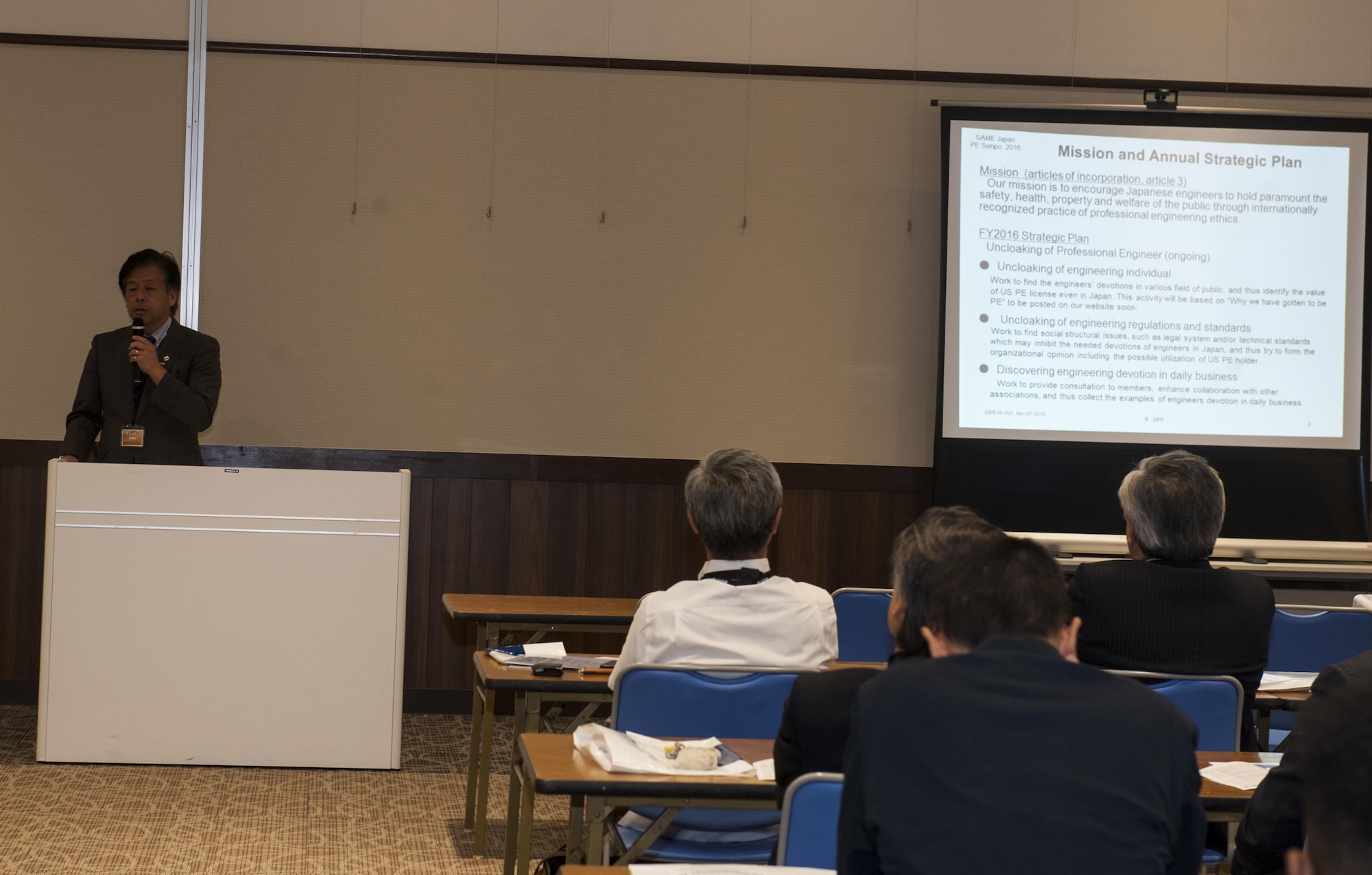 Takeya Kawamura, Japan Society of Professional Engineers president, speaks about the mission of the Society of American Military Engineers Japan Post during a symposium Nov. 7, 2016, in Okinawa, Japan. The SAME Japan Post involves leadership from different areas of engineering across Japan. (U.S. Air Force photo by Senior Airman Lynette M. Rolen/Released)