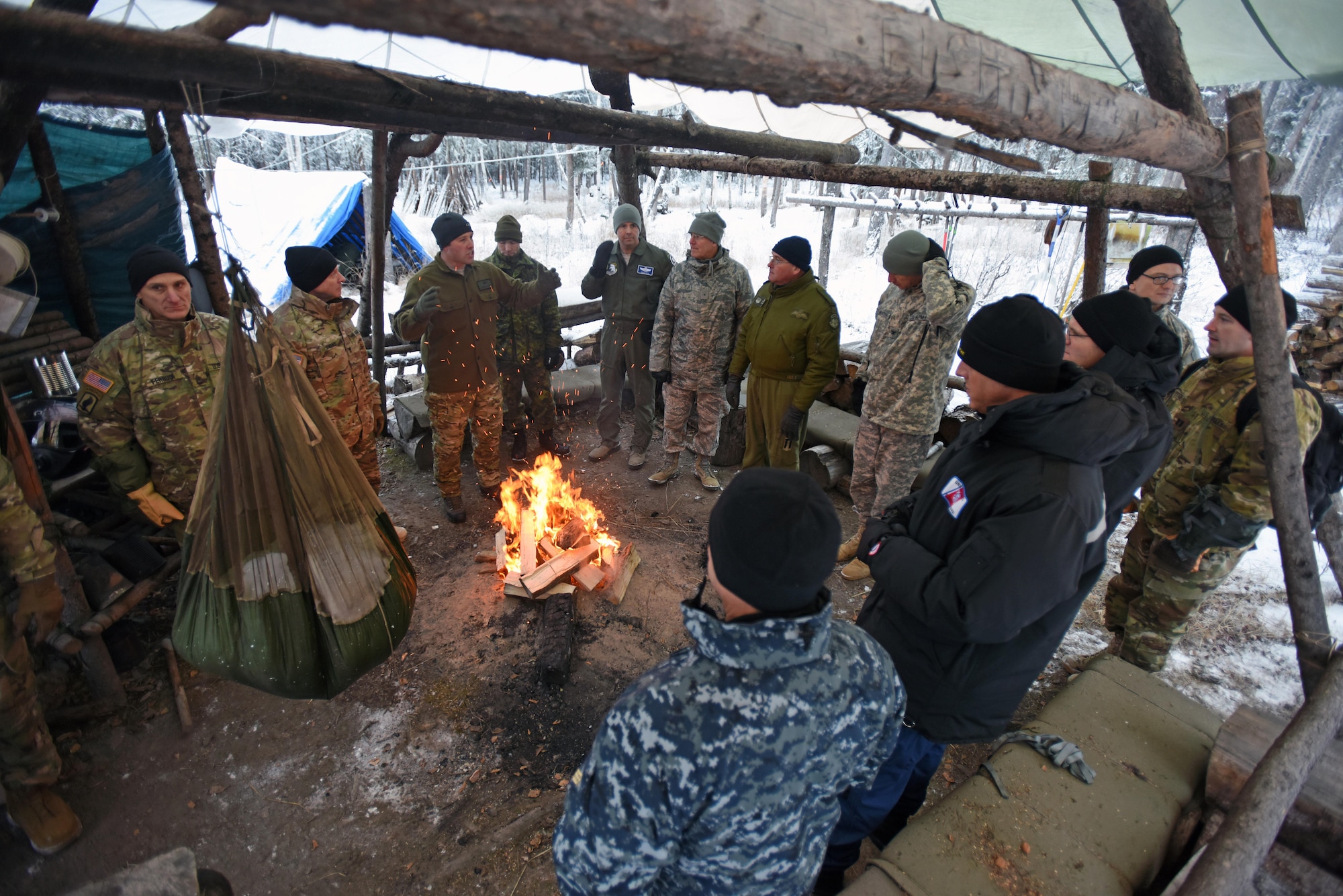 U.S. Air Force Master Sgt. Marc Richard, Arctic Cool School Survival, Evasion, Resistance, and Escape instructor, shows participants of the Arctic General Officer/Flag Officer Summit the importance of building a fire in the Arctic in order to melt snow and obtain water Nov. 9. U.S. Air Force Lt. Gen. Ken Wilsbach, Alaskan NORAD Region, Alaskan Command and 11th Air Force commander and U.S. Army Maj. Gen. Bryan Owens, U.S. Army Alaska commander hosted the conference, which included flag officers from the U.S. Air Force, U.S. Army, U.S. Coast Guard, Alaska National Guard and Canadian Forces, to strengthen partnerships, discuss future Arctic and Alaskan challenges and joint capabilities. 