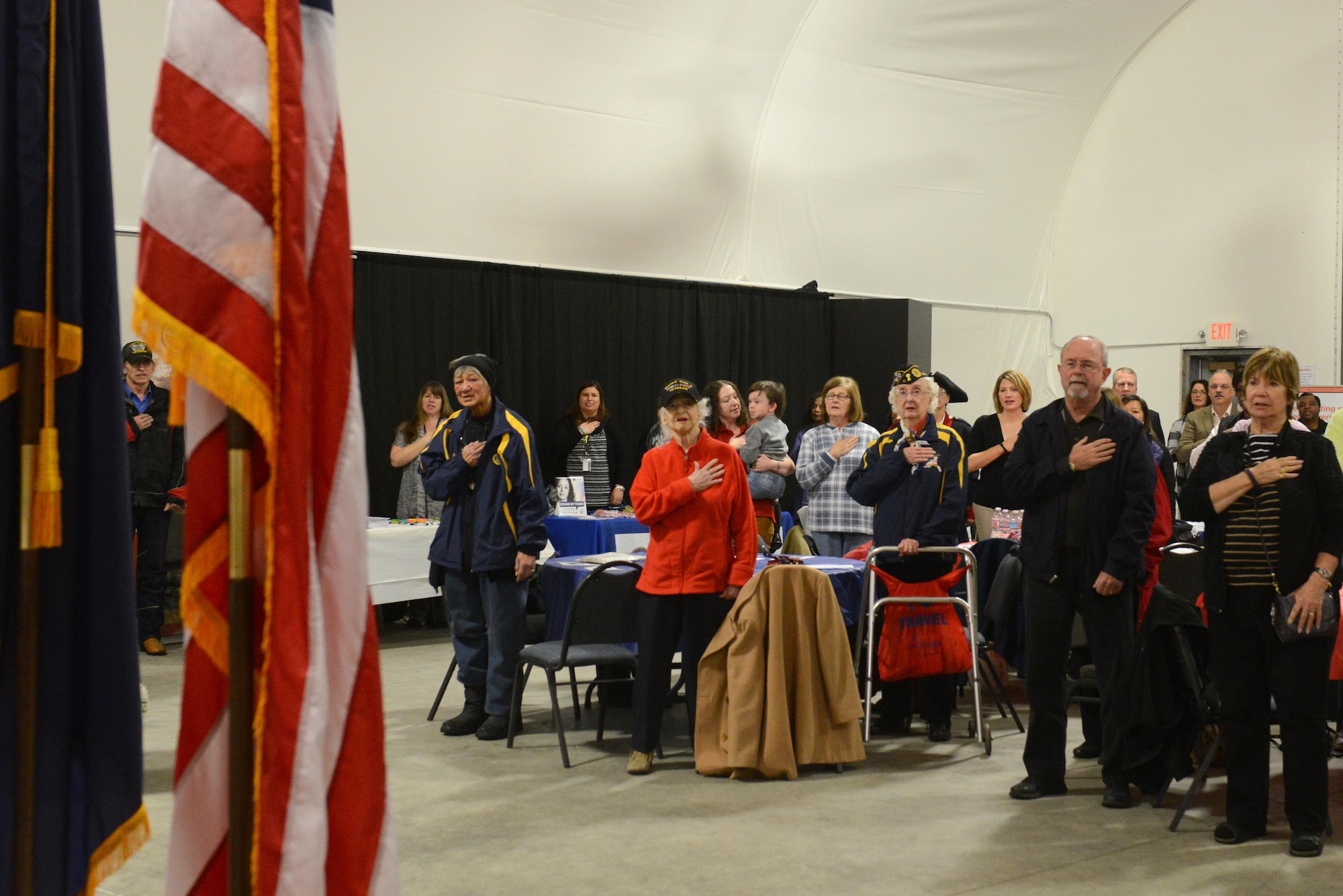 Participants of the Women Veterans Recognition ceremony hosted by the Women Veterans Program place their hands on their hearts during a playing of the national anthem at the Alaska Aviation Museum, Anchorage, Nov. 9, 2016. The event recognized and highlighted the contributions female veterans have made and continue to make in the military.