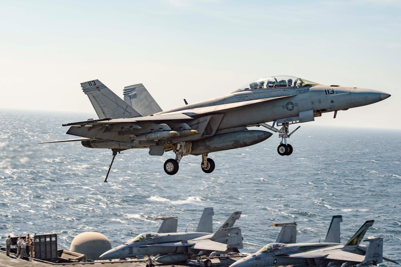 An F/A-18F Super Hornet assigned to the Fighting Swordsmen of Strike Fighter Squadron 32 flies over the aircraft carrier USS Dwight D. Eisenhower in the Persian Gulf, Nov. 10, 2016. Navy photo by Petty Officer 3rd Class Nathan T. Beard
