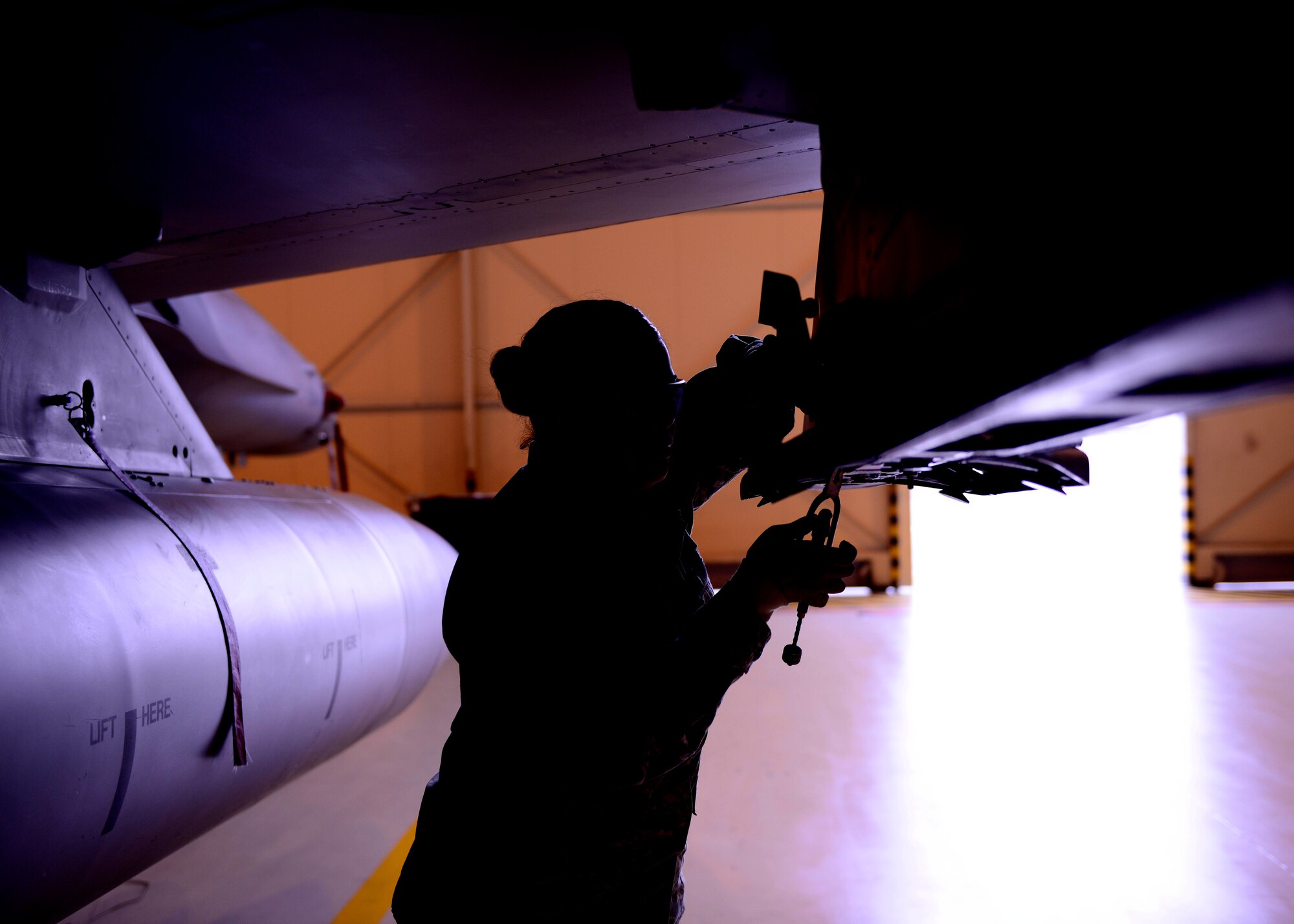 Airman 1st Class Arlene Castro-Lopez, 31st Aircraft Maintenance Squadron weapons load crew member, loosens bolts during a weapons loading demonstration at Aviano Air Base, Italy on Nov. 11, 2016. Weapons load crew members are responsible for loading and unloading munitions on Team Aviano’s F-16 Fighting Falcons.  (U.S. Air Force photo by Senior Airman Areca T. Bell)