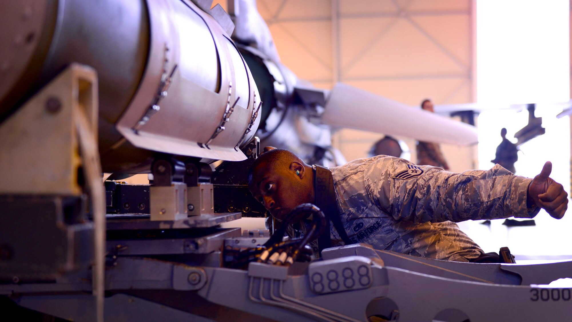 Staff Sgt. Tyrral Leach, 31st Aircraft Maintenance Squadron weapons load crew supervisor, helps place an ordnance onto a munitions rack during a weapons loading demonstration at Aviano Air Base, Italy on Nov. 11, 2016. Load teams include three Airmen who each perform separate tasks to safely load munitions onto F-16 Fighting Falcons. (U.S. Air Force photo by Senior Airman Areca T. Bell)