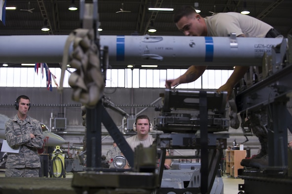 Evaluators observe Staff Sgt. Daniel Vazquez, left, and Airman 1st Class Christian Edson, right, both 52nd Aircraft Maintenance Squadron tactical aircraft weapons systems specialist, as Edson positions the MJ-IC jammer boom during the 52nd Fighter Wing Load Crew of the Quarter competition Nov. 10, 2016. The load crew competition required two teams of three competing members to load weapons to the wings of an F-16 Fighting Falcon as quickly and accurately as possible. (U.S. Air Force photo by Senior Airman Dawn M. Weber)