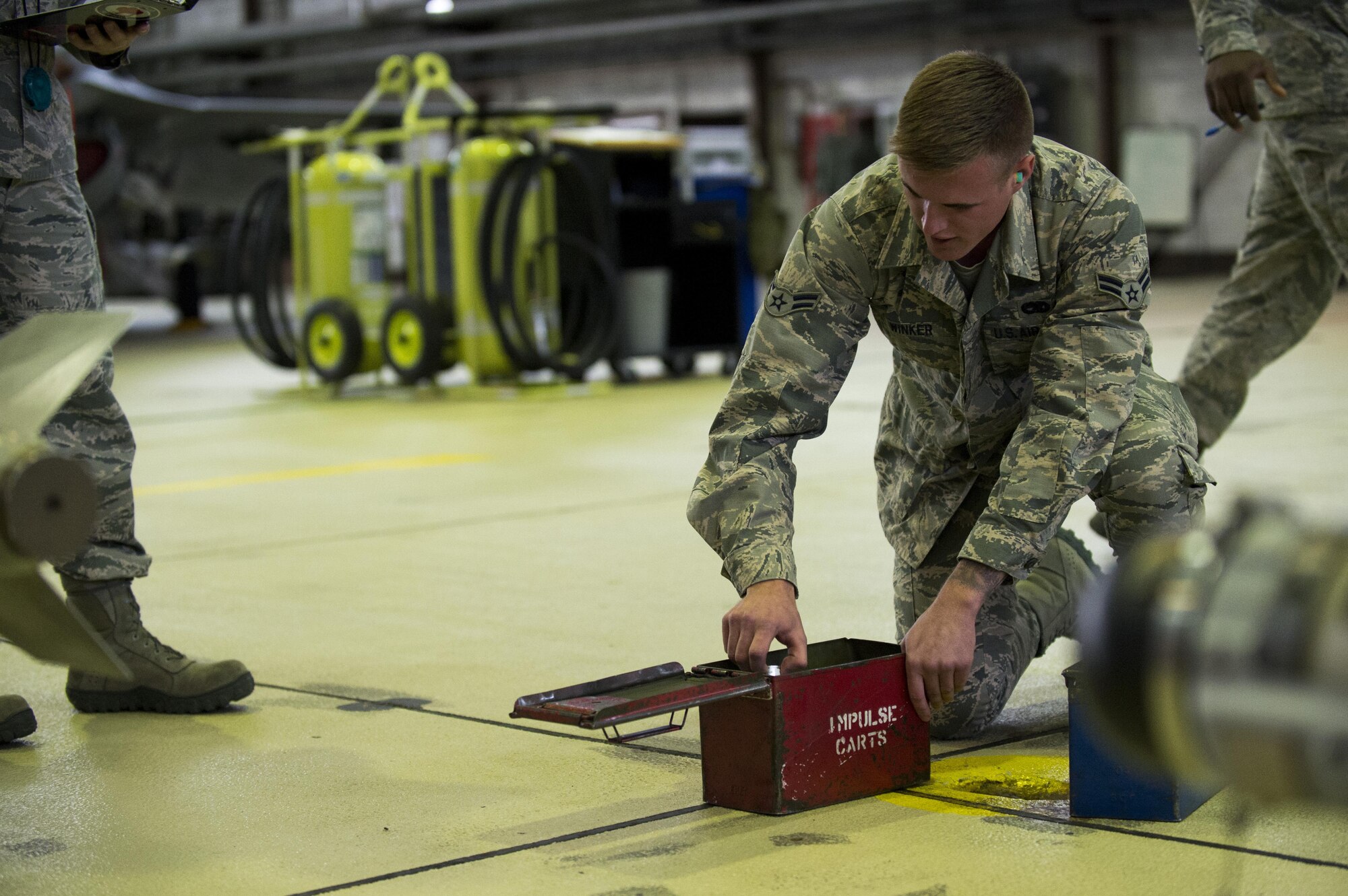 U.S. Air Force Airman 1st Class Austin Winker, 52nd Aircraft Maintenance Squadron weapons load crew member, identifies parts before loading inert weapons during the quarterly weapons load competition in Hangar One at Spangdahlem Air Base, Germany, Nov. 10, 2016. Family, friends and coworkers watched as two teams competed against each other for a spot in the annual load competition. (U.S. Air Force photo by Airman 1st Class Preston Cherry)