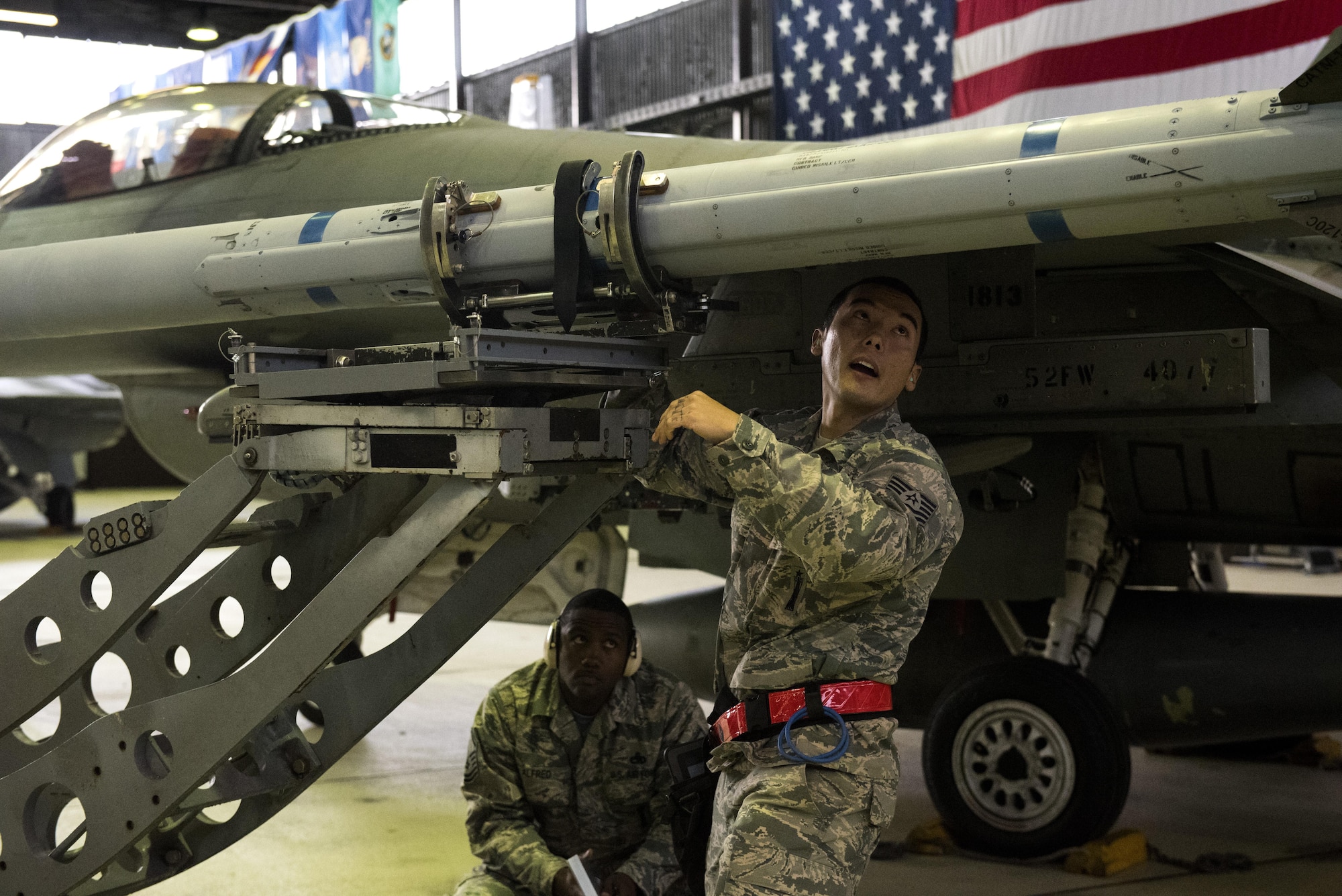 U.S. Air Force Tech. Sgt. Robert Morley, right, 52nd Aircraft Maintenance Squadron weapons load crew chief, loads an inert weapon on an F-16 Fighting Falcon during the quarterly weapons load competition in Hangar One at Spangdahlem Air Base, Germany, Nov. 10, 2016. The competition consisted of two teams competing against each other to load weapons quickly and accurately. (U.S. Air Force photo by Airman 1st Class Preston Cherry)