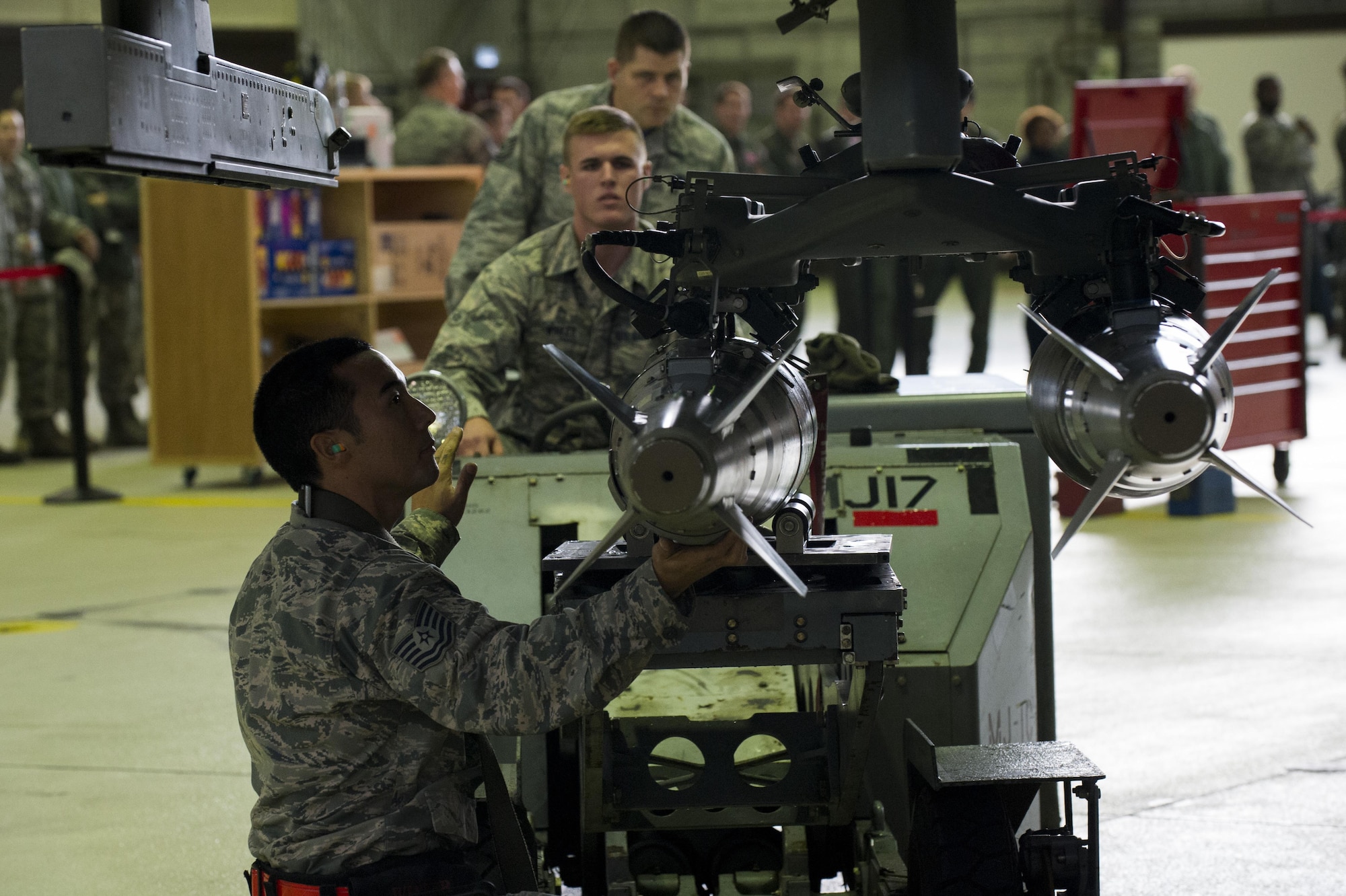 U.S. Air Force Airman 1st Class Austin Winker, center, 52nd Aircraft Maintenance Squadron weapons load crew member, and Tech. Sgt. Robert Morely, left, 52nd Aircraft Maintenance Squadron weapons load crew chief, load inert missiles on an F-16 Fighting Falcon during the quarterly weapons load competition in Hangar One at Spangdahlem Air Base, Germany, Nov. 10, 2016. Load crew members competed against the clock and each other to load an F-16 with fewer discrepancies than their competitor. (U.S. Air Force photo by Airman 1st Class Preston Cherry)