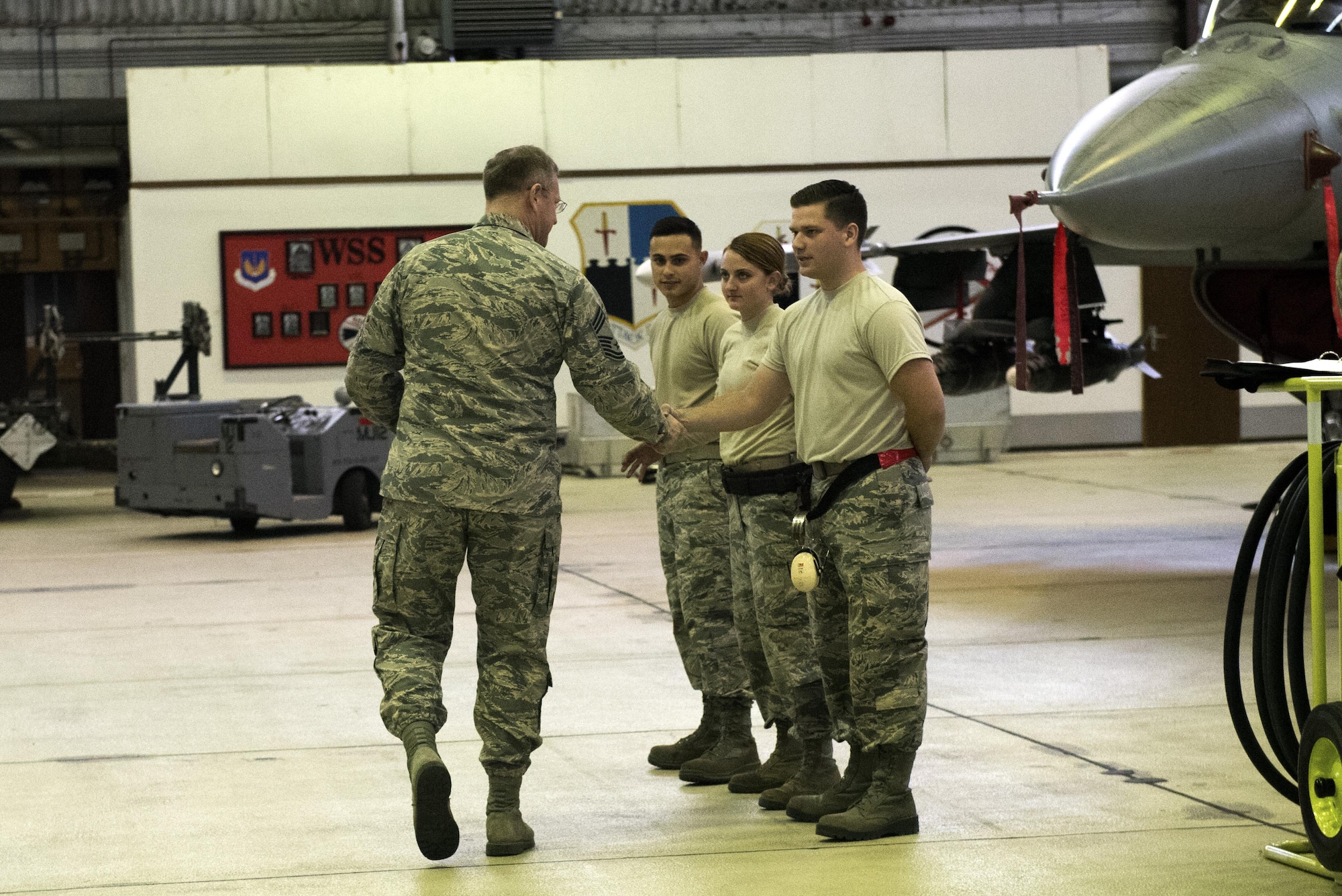 U.S. Air Force Chief Master Sgt. Craig Brandenburg, left, 52nd Maintenance Group wing weapons manager, congratulates the winning Aircraft Maintenance Squadron load crew members during the quarterly weapons load competition in Hangar One at Spangdahlem Air Base, Germany, Nov. 10, 2016. The competition consisted of two teams, each with three load crew members, competing for a spot in the annual load competition.  (U.S. Air Force photo by Airman 1st Class Preston Cherry)