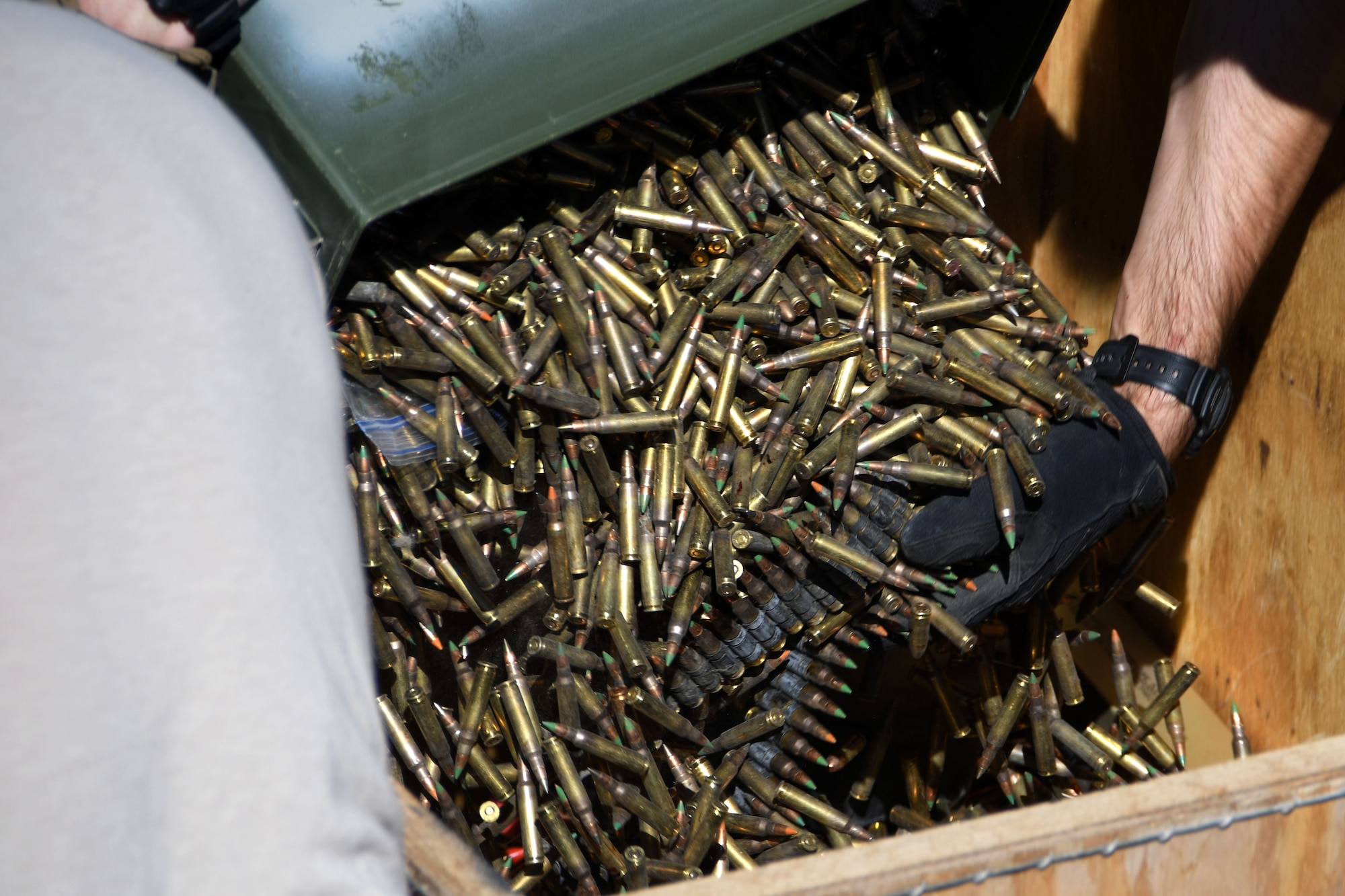 A member of the 386th Expeditionary Civil Engineer Squadron Explosive Ordnance Disposal flight pours unserviceable ammunition into a wooden box at an undisclosed location in Southwest Asia Nov. 9, 2016. A total of 18,974 pieces of unserviceable ammunition was destroyed. (U.S. Air Force photo by Senior Airman Andrew Park)