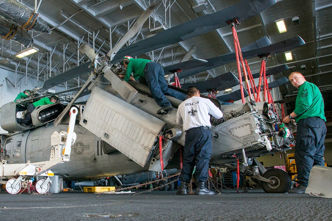 Sailors perform maintenance on an MH-60S Sea Hawk helicopter in the hangar bay aboard the aircraft carrier USS Carl Vinson in the Pacific Ocean, Nov. 9, 2016. The sailors are assigned to Helicopter Sea Combat Squadron 4. The Carl Vinson Carrier Strike Group was conducting an extensive month-long underway off the coast of Southern California. During their time at sea, the strike group will conduct various exercises and complete evaluations to certify their ships as deployment ready. Navy photo by Petty Officer 2nd Class D’Andre L. Roden