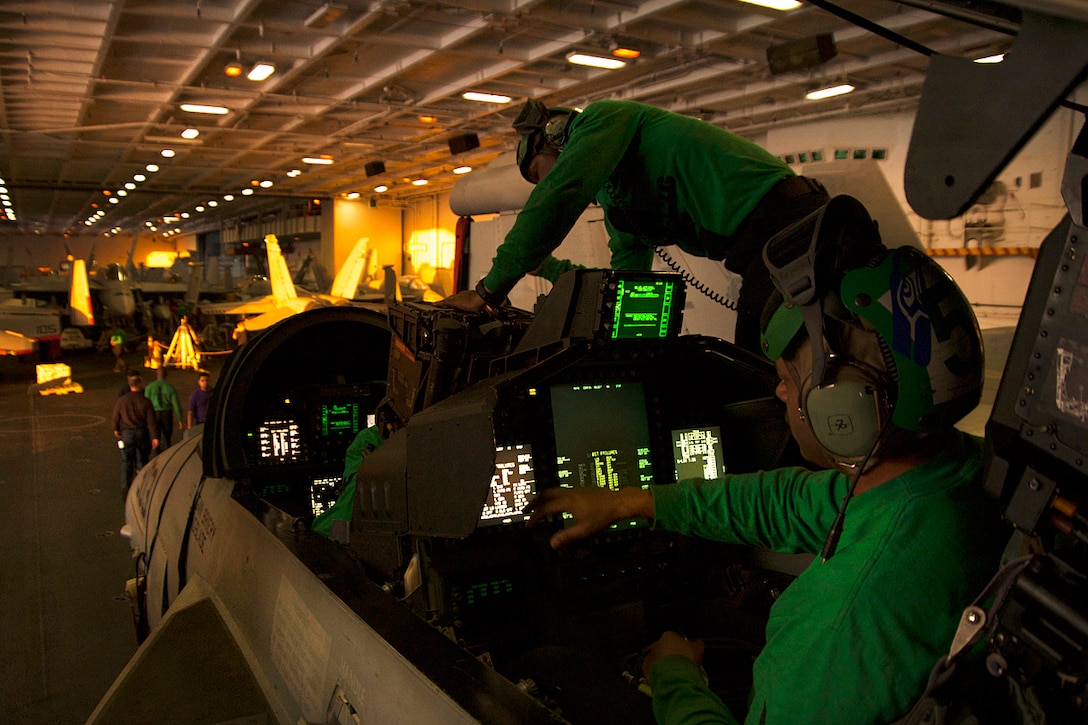 Sailors perform maintenance on an EA-18G Growler in the hangar bay aboard the aircraft carrier USS Carl Vinson in the Pacific Ocean, Nov. 11, 2016. The sailors are assigned to Electronic Attack Squadron 136. Navy photo by Seaman Theo Shively