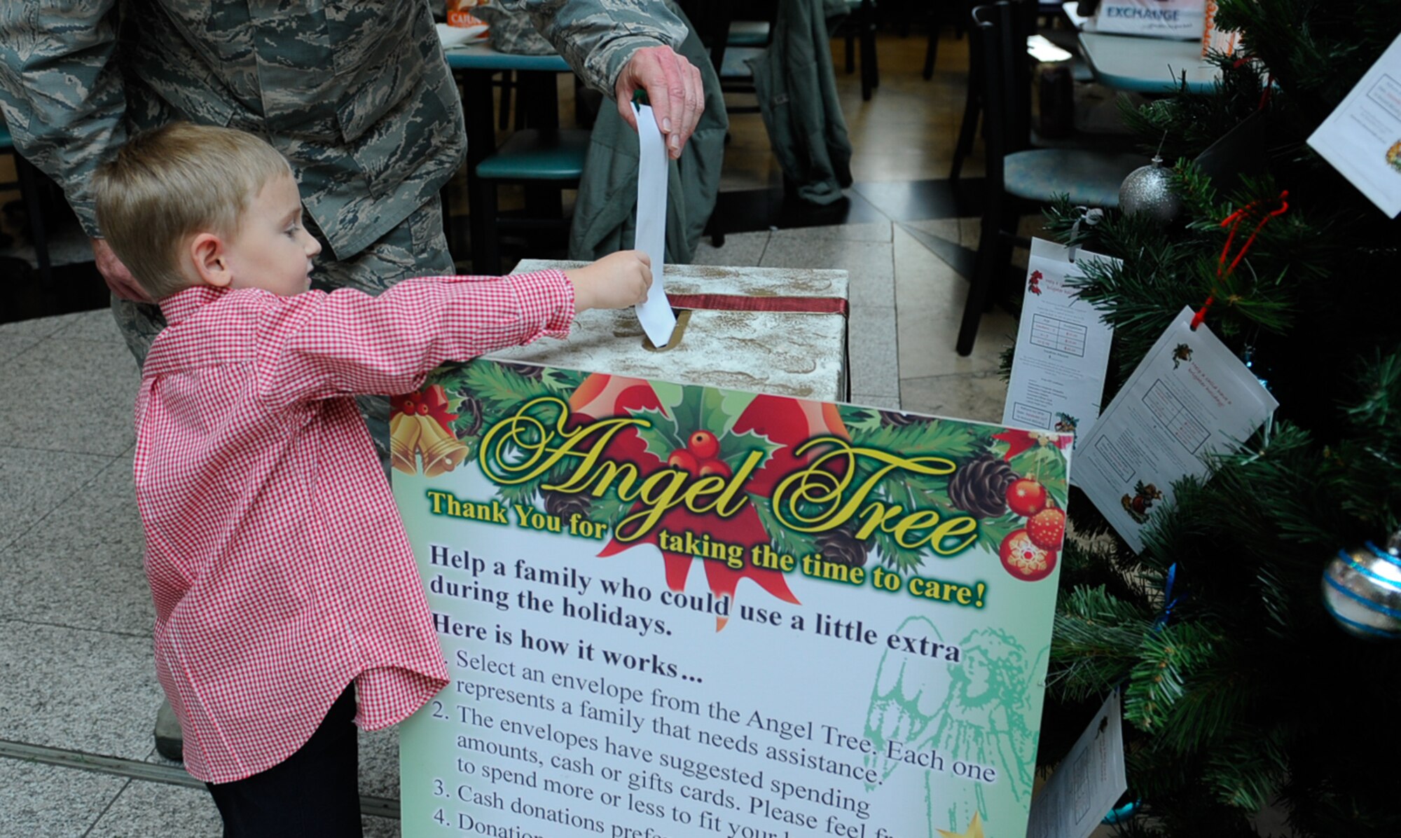 Wyatt Jacobs, son of Chief Master Sgt. Taylor Jacobs, 21st Operational Weather Squadron superintendent, places an Angel Tree donation into a box at Ramstein Air Base, Germany, Nov. 8, 2016. The Angel Tree program provides assistance to see Airmen through unforeseen financial difficulties. (U.S. Air Force photo by Airman 1st Class Savannah L. Waters)

