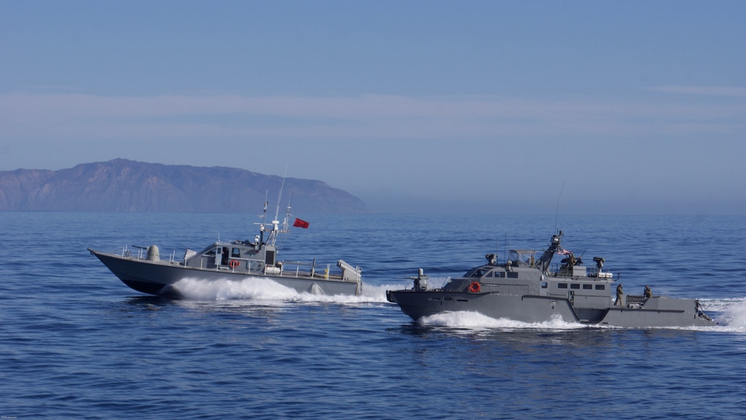 A U.S. Navy Mark VI patrol boat wards off a Guardian Fast Patrol Craft, simulating the actions of an enemy vessel during a show of force strait transit with Carrier Strike Group 1 off the coast of Southern California, Nov. 4, 2016. 