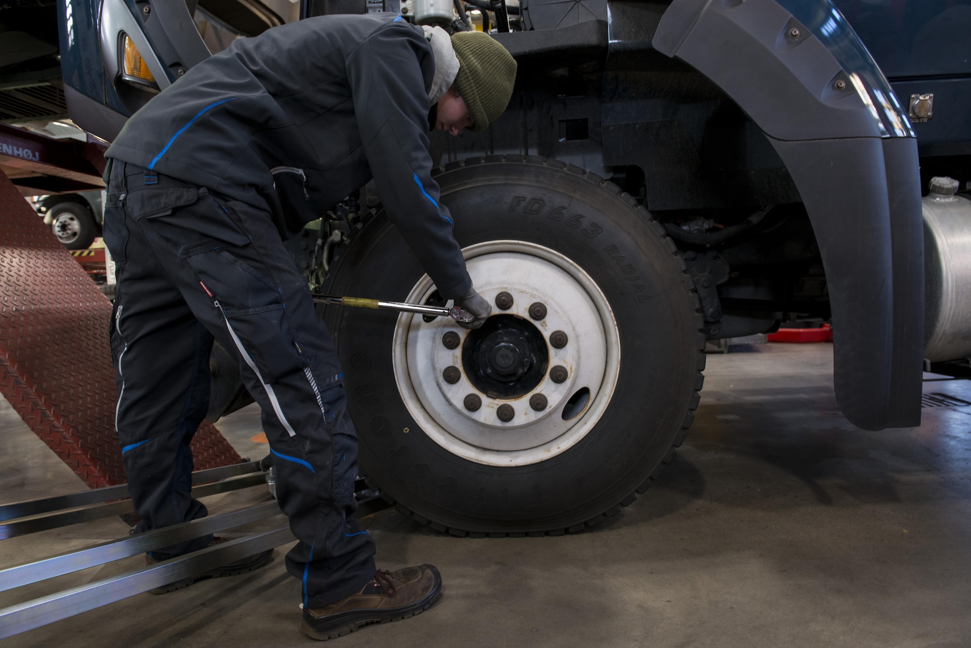 Hendrik Ecker, 86th Vehicle Readiness Squadron vehicle mechanic technician, removes a lug nut from a tire at Ramstein Air Base, Germany, Nov. 14, 2016. Ramstein recently revived its Local National Apprenticeship program, choosing 21 local nationals, including Ecker, for vocational training. He will be working alongside the 86th VRS Airmen for three-and-a-half to four years. (U.S. Air Force photo by Senior Airman Tryphena Mayhugh)