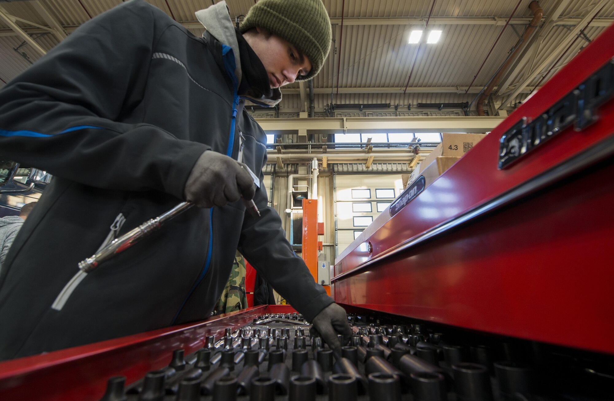Hendrik Ecker, 86th Vehicle Readiness Squadron vehicle mechanic technician, selects a tool at Ramstein Air Base, Germany, Nov. 14, 2016. Ecker was interested in vehicle maintenance at age fourteen and was able to partner with the 86th VRS to gain the skills and knowledge of the craft through Ramstein’s Local National Apprenticeship program. He is specializing in large vehicle maintenance. (U.S. Air Force photo by Senior Airman Tryphena Mayhugh)