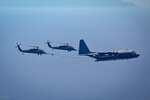 Two HH-60G Pave Hawk rescue helicopter and an MC-130P Combat Shadow aircraft, assigned to the 129th Rescue Wing, California Air National Guard, conduct an aerial refuel operations over the Pacific Ocean, April 3, 2014. 